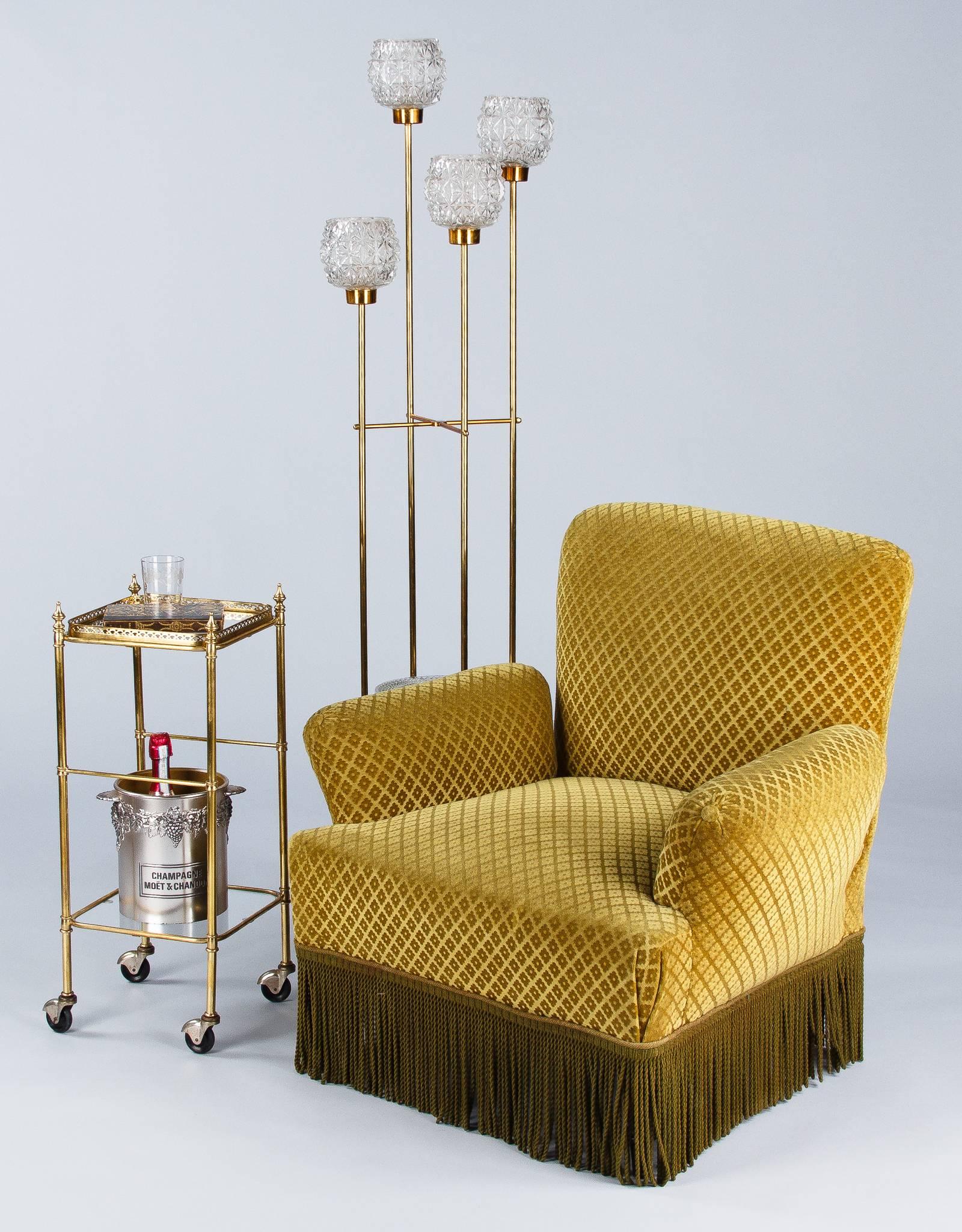 A charming 1950s small French two-tier side table made of polished brass and rolls on rubber wheels. The upper shelf features a brass galleried glass top. The bottom shelf is clear glass.