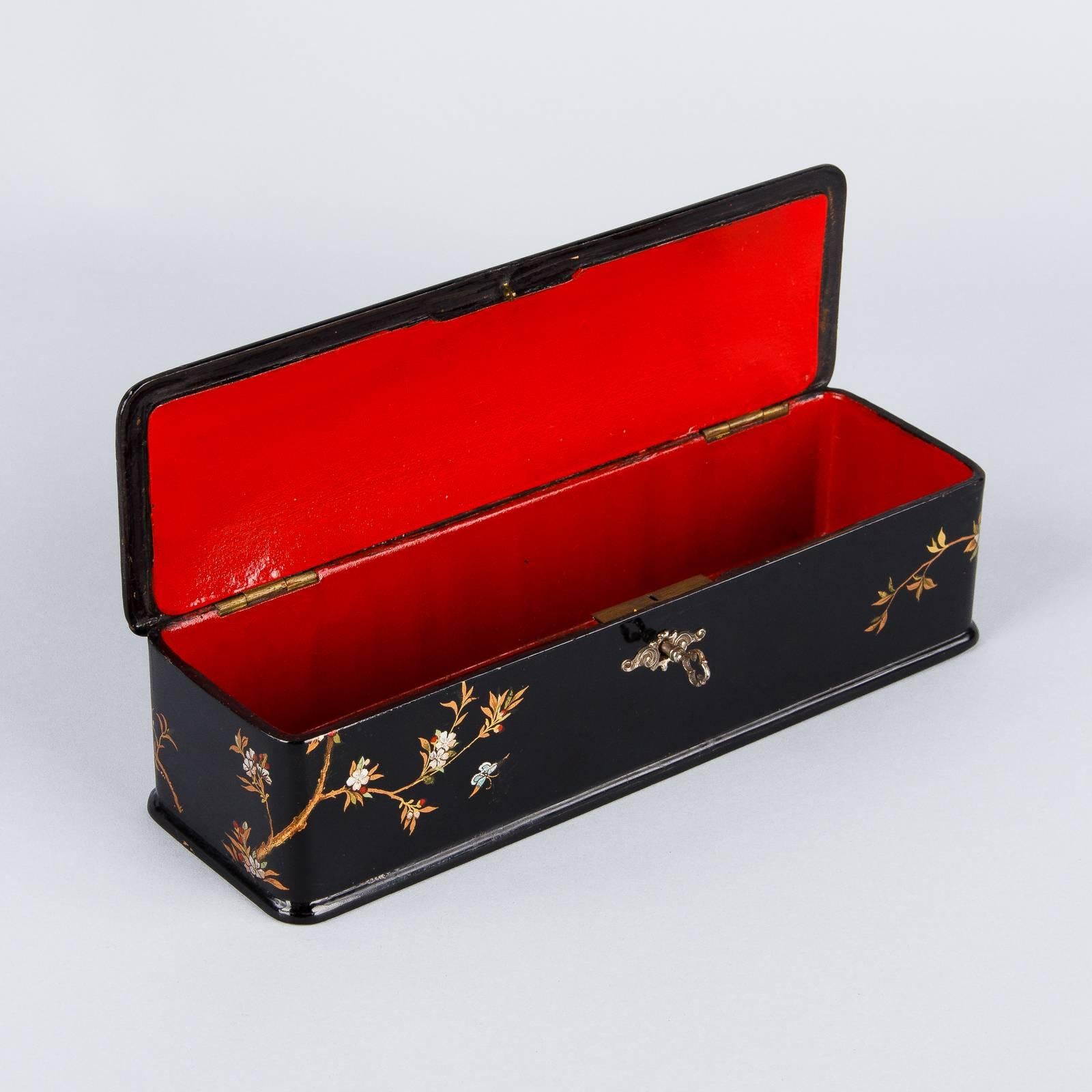 A Napoleon III period box made of lacquered blackwood with chinoiserie motifs. The inside is wood painted red. The box has its own key.