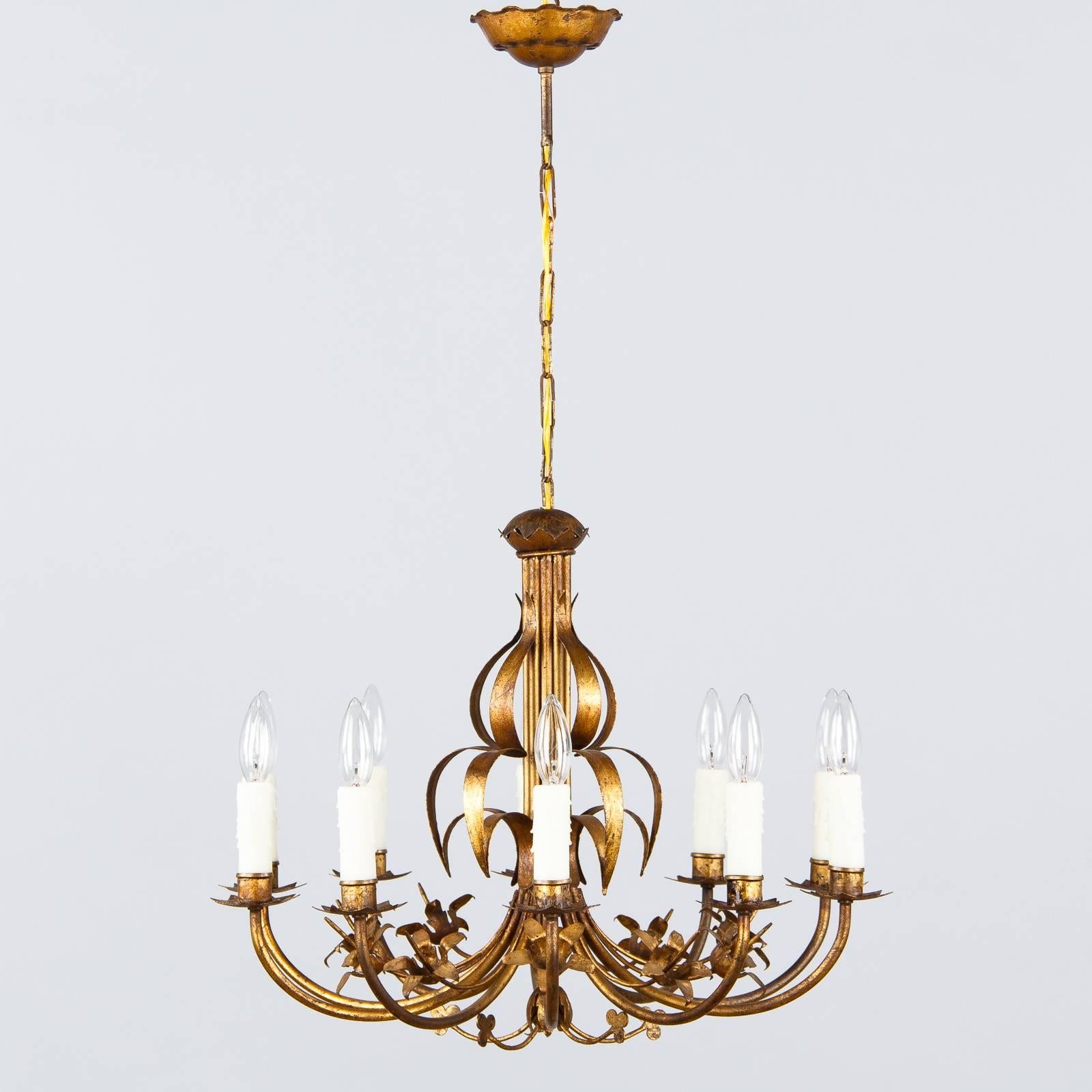A ten-light French gilded metal chandelier that was found in a private home in the Loire region. The fixture features designs of stars, flowers and clovers. The adjustable chain and canopy add 16.5