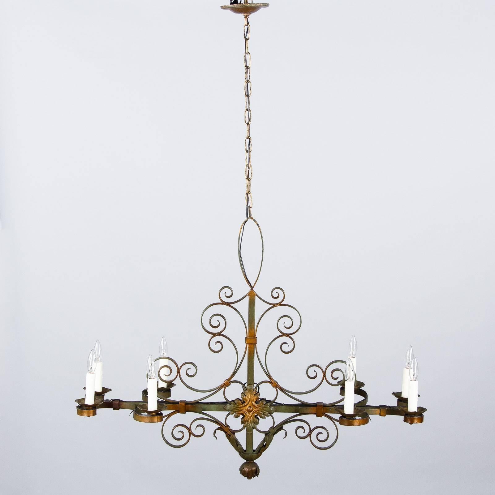 This eight-light French forged iron chandelier has a beautiful green and bronze patina and scroll motifs. The adjustable chain and canopy add 24" to the fixture.