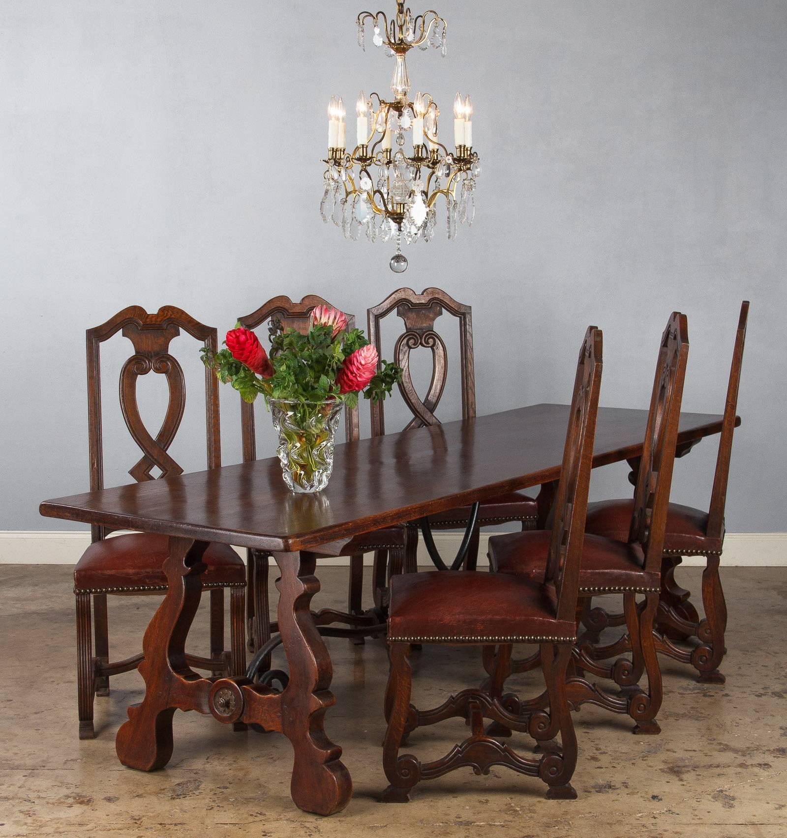 A beautiful trestle table from Spain made of oak with a scrolled iron stretcher. A fine dining table that can accommodate 10 guests. Floor to Apron: 27.75