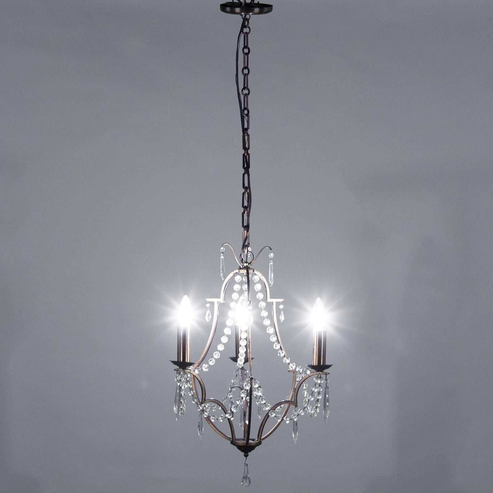 A late 1800's small 3-light Chandelier purchased in Lyon. The light fixture is made of gilded bronze with crystals.