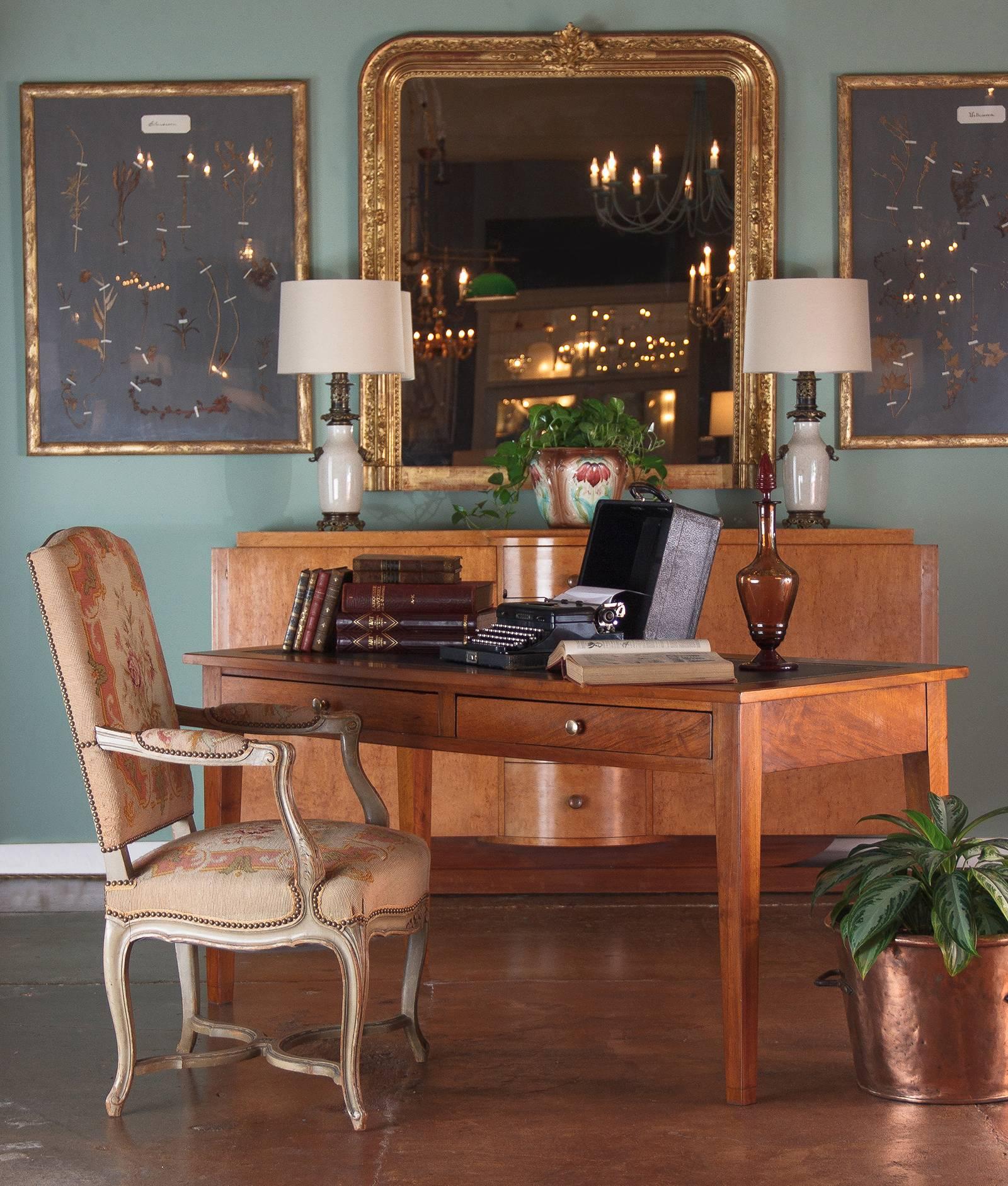 A beautiful French Louis XVI style desk in cherrywood with tapered legs featuring an embossed black leather top and two drawers with brass knobs. A perfect desk, console or writing table! From floor to apron: 24.5