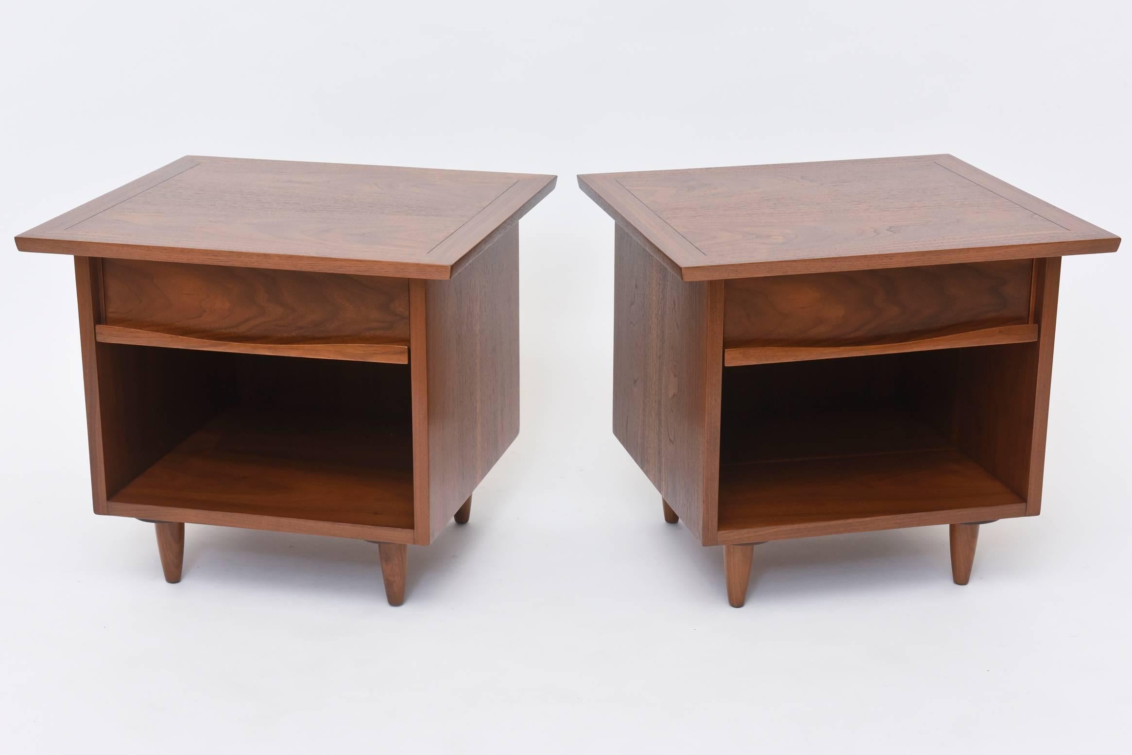 The square top with scored line border, above a drawer with highly figured walnut front and sculpted pull, above a cubby, on round tapering legs.