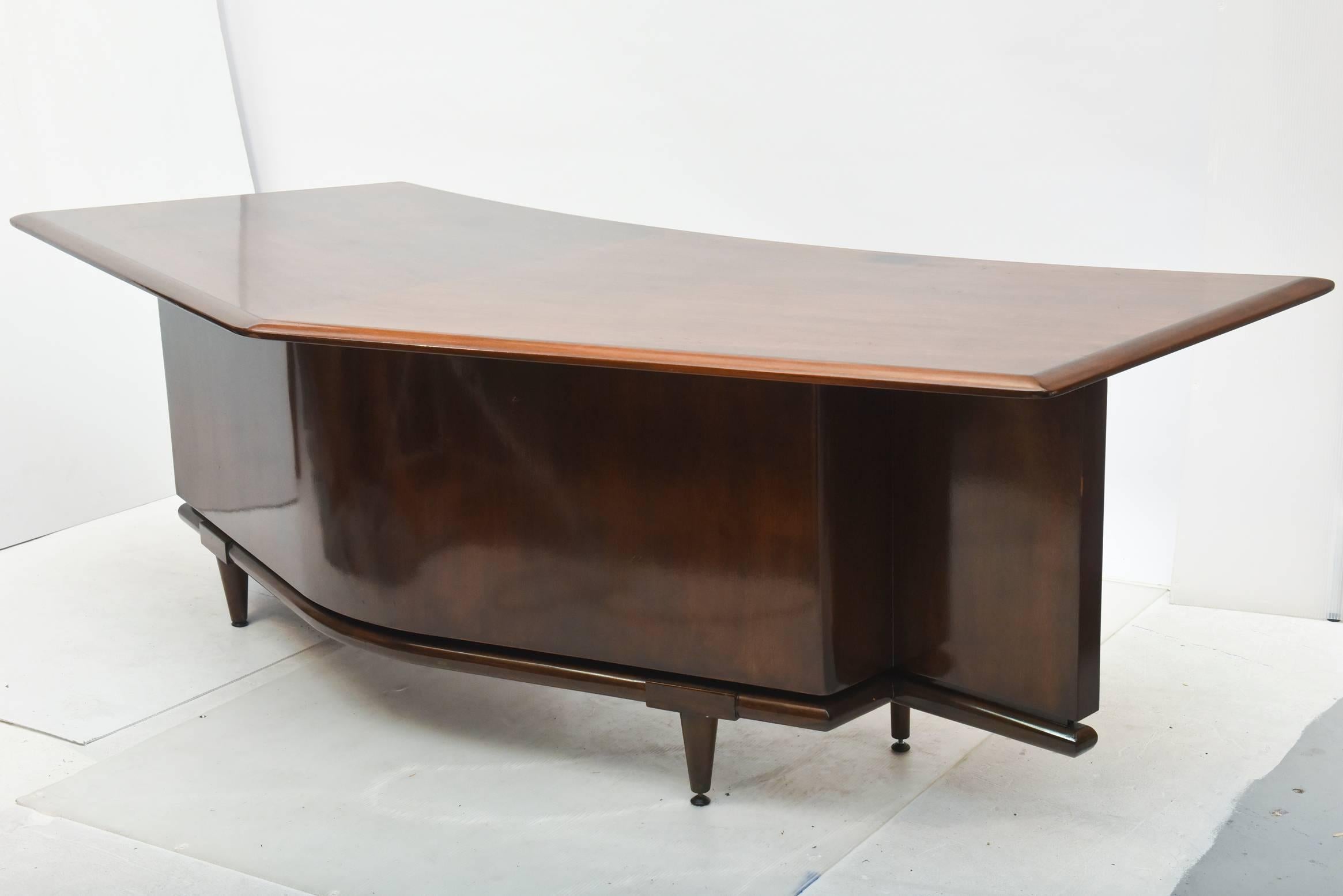 the chevron shaped top above a conforming body with architectural details, with three drawers and a long pencil drawer, with an addition large/ file drawer, on round tapering legs
provenance the estate of Steve McQueen, thence by descent
small