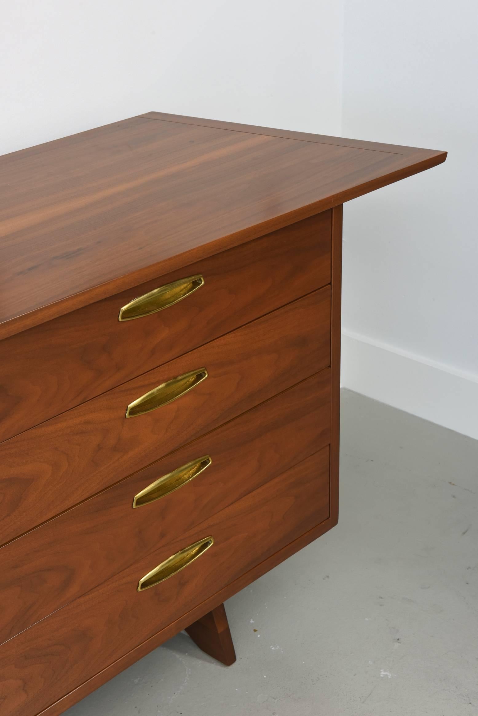 The overhanging irregular shape top above 12 drawers with brass pulls, on splayed legs
George Nakashima for Widdicomb.