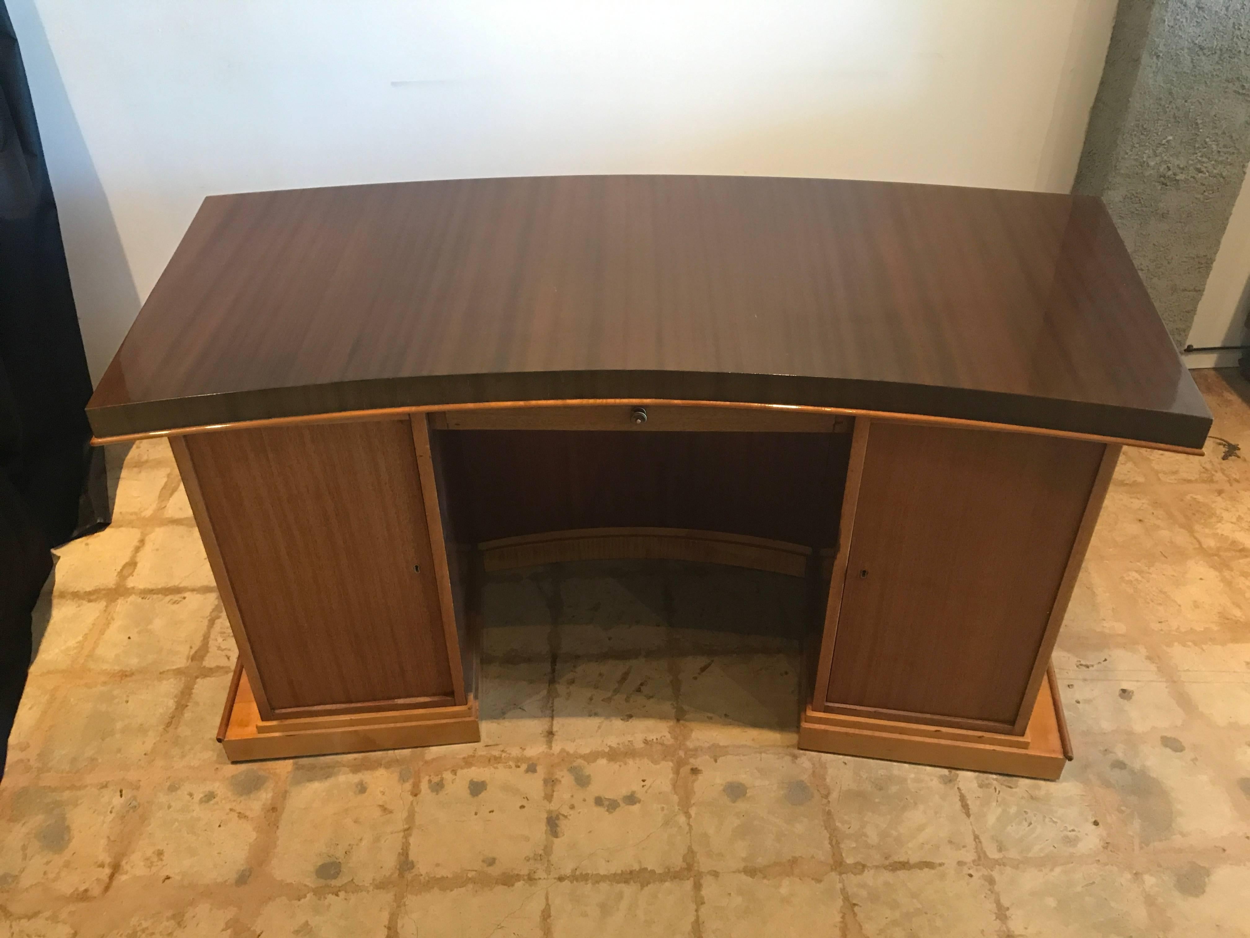 The shaped semi-circular rosewood top above a curving base the reverse with two cabinet doors and a drawer, on a rectangular base
literature- Jacques Adnet-Gaelle Hardy Alain-Rene Millet.