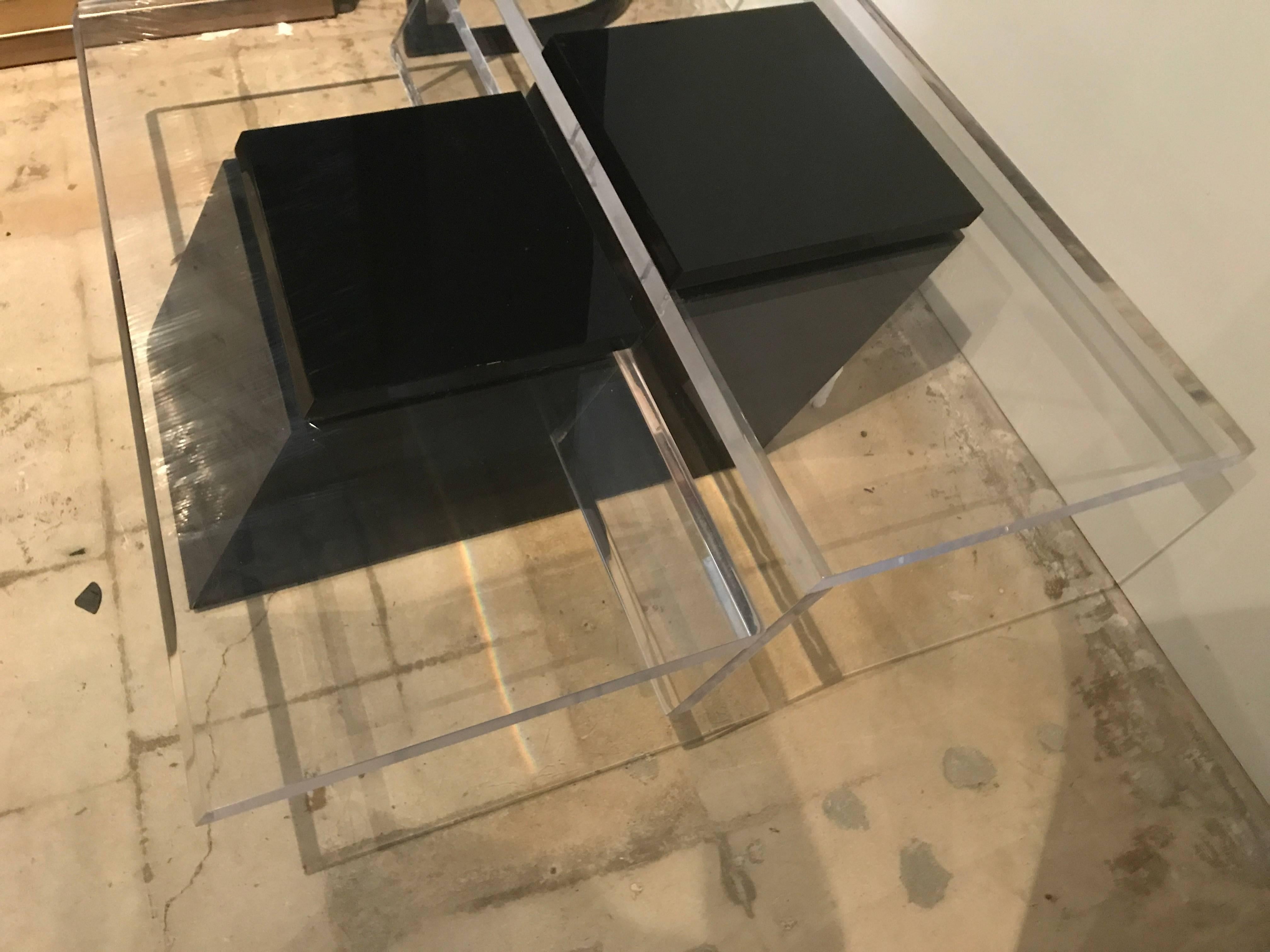 The clear Lucite top in steps, with a central black Lucite structure, on a lacquer base- lower shelf is 16" and higher is 17.5.