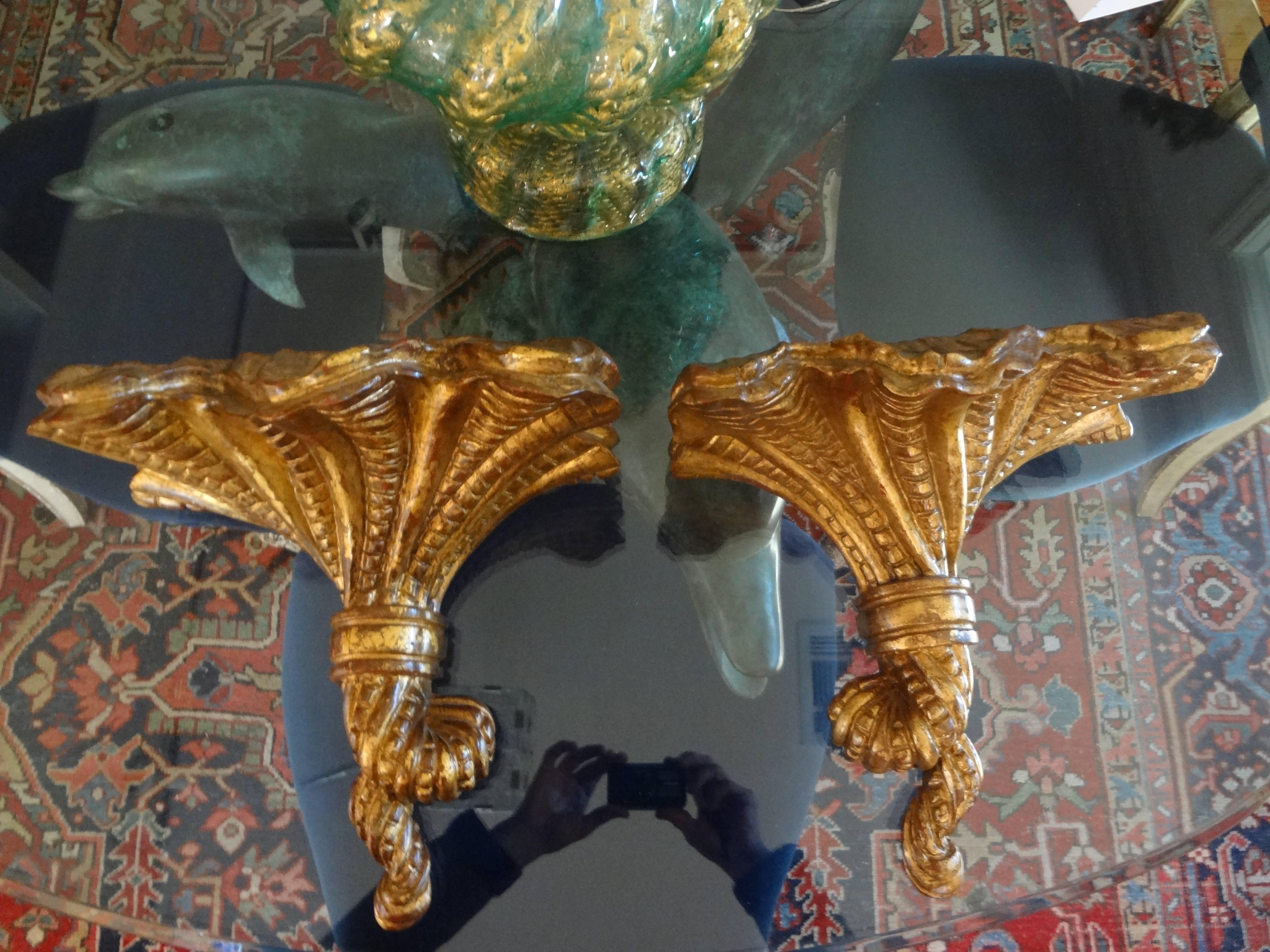 Opposing pair of midcentury Italian gilt wood wall shelves. This pair of Italian giltwood wall brackets or wall consoles date to the 1940s.
