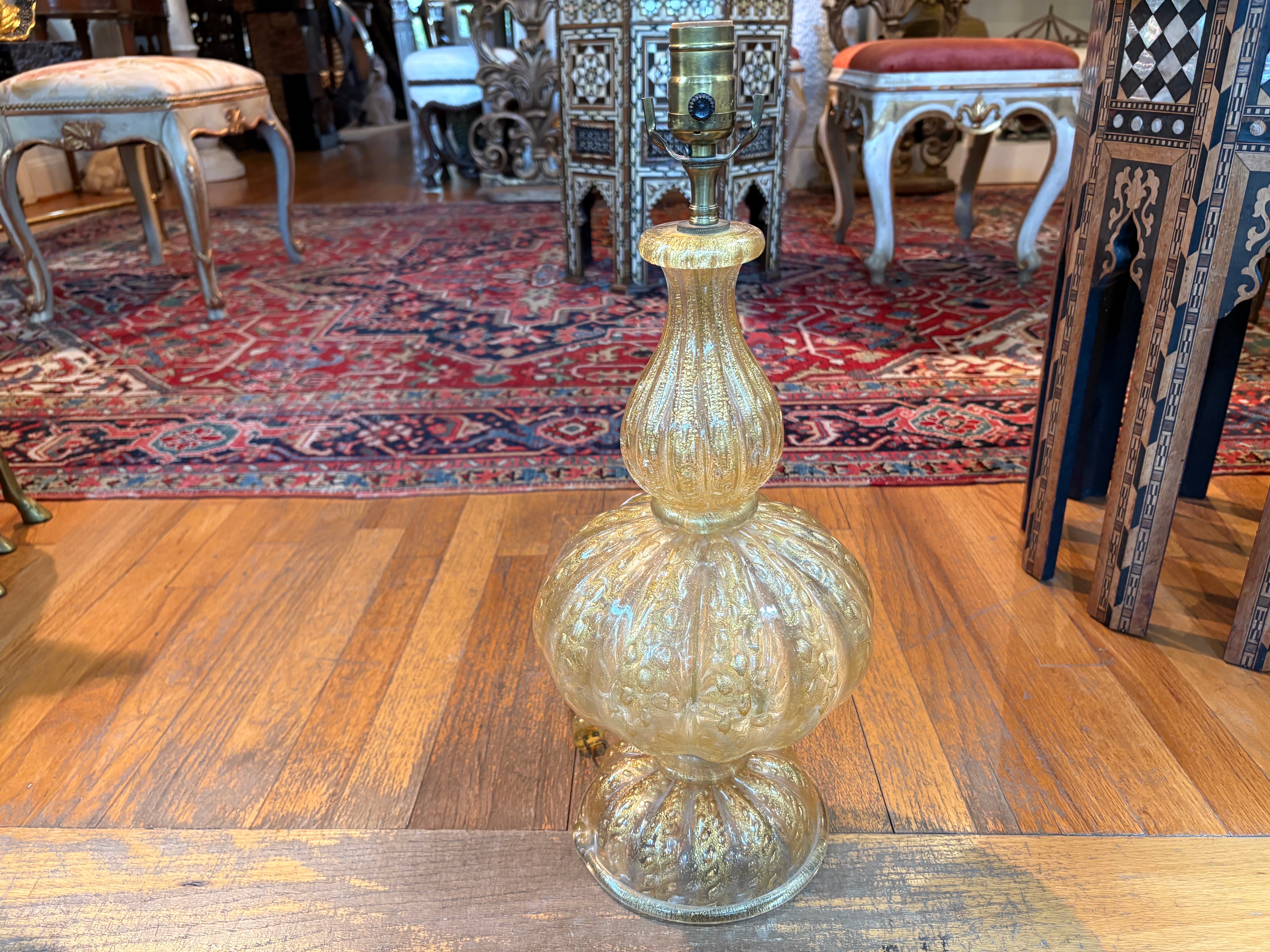 Lampe en verre Murano doré.
Nous vous proposons une belle lampe de Murano, probablement de Barovier, d'une belle couleur dorée avec des mouchetures dorées. Notre lampe en verre vénitien a été récemment recâblée avec une nouvelle douille et est prête