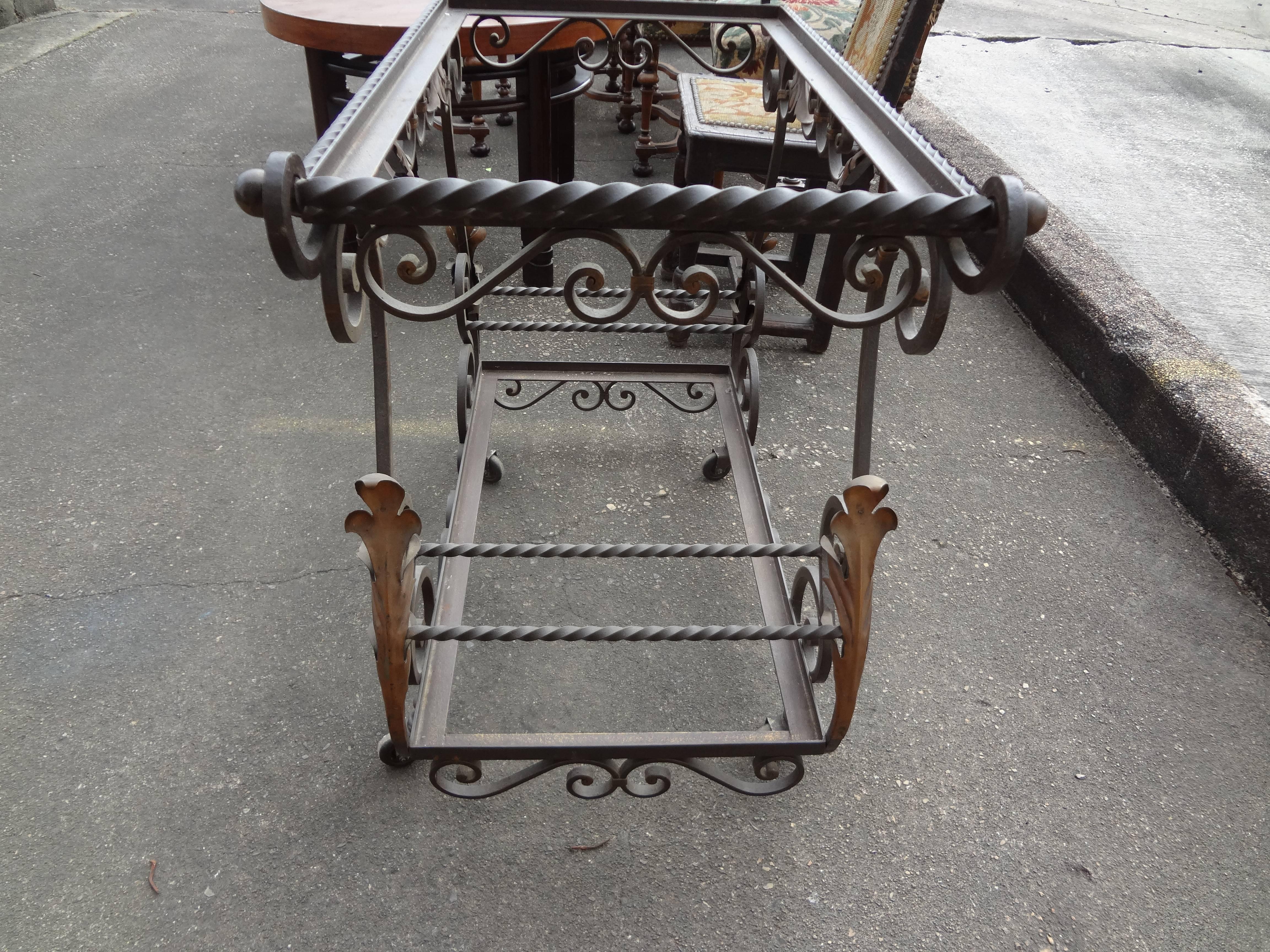 Interesting French heavy gauge hand-forged wrought and gilt iron serving cart or bar cart inspired by Gilbert Poillerat.
On casters with glass shelves.

 