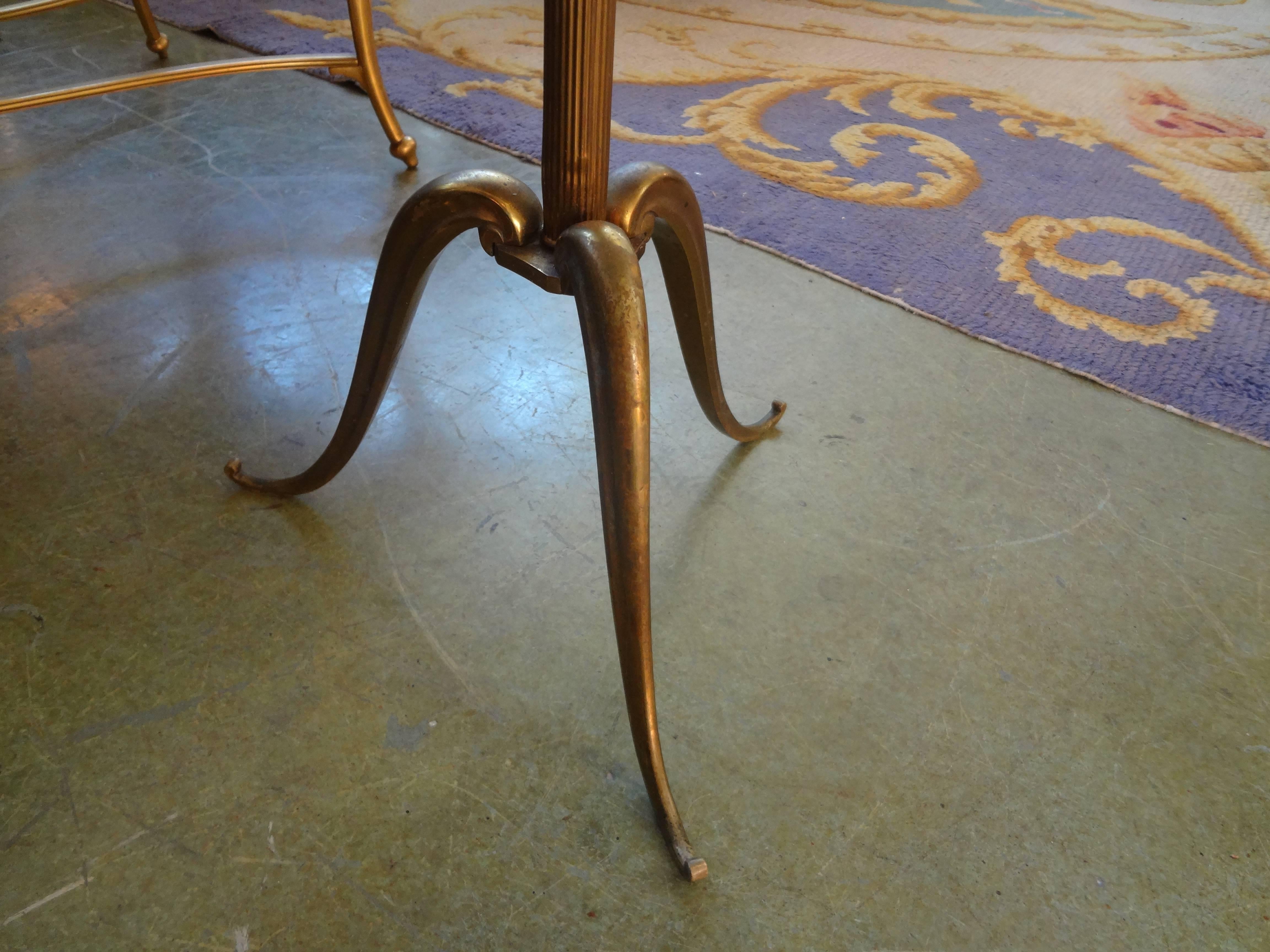 Stylish French 1940's bronze or brass table with tripod legs and gallery top with marbellized mirror in The Style Of Jacques Adnet, circa. 1940. Gorgeous patina to bronze.