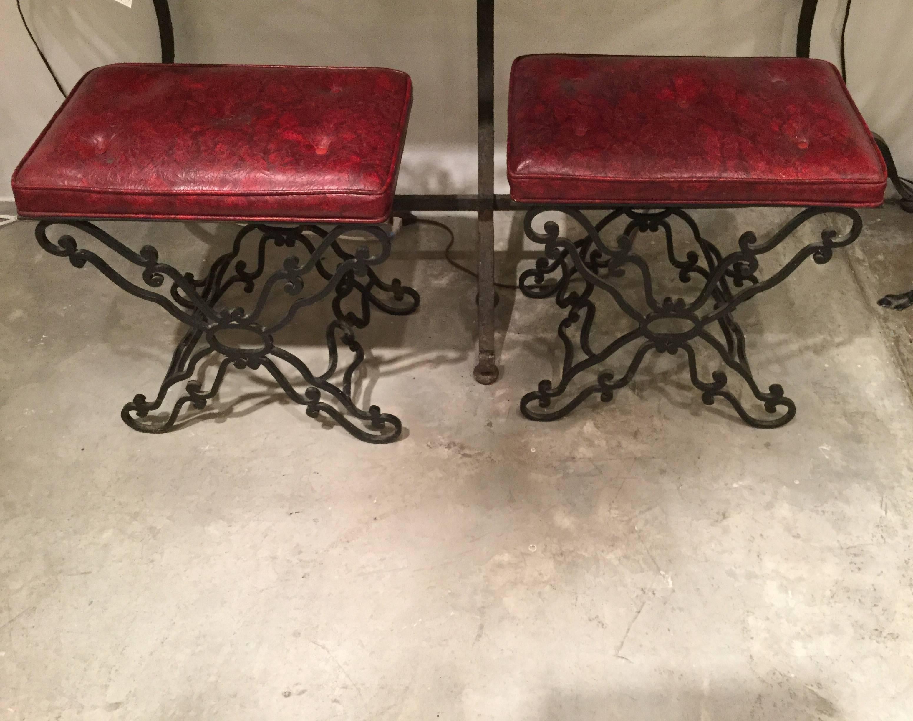 Matching pair of continental hand-forged wrought iron ottomans or stools with beautiful detailing, circa 1930-1940. Currently upholstered in vinyl, easy to re upholster.
Would work well in a variety of interiors.
      