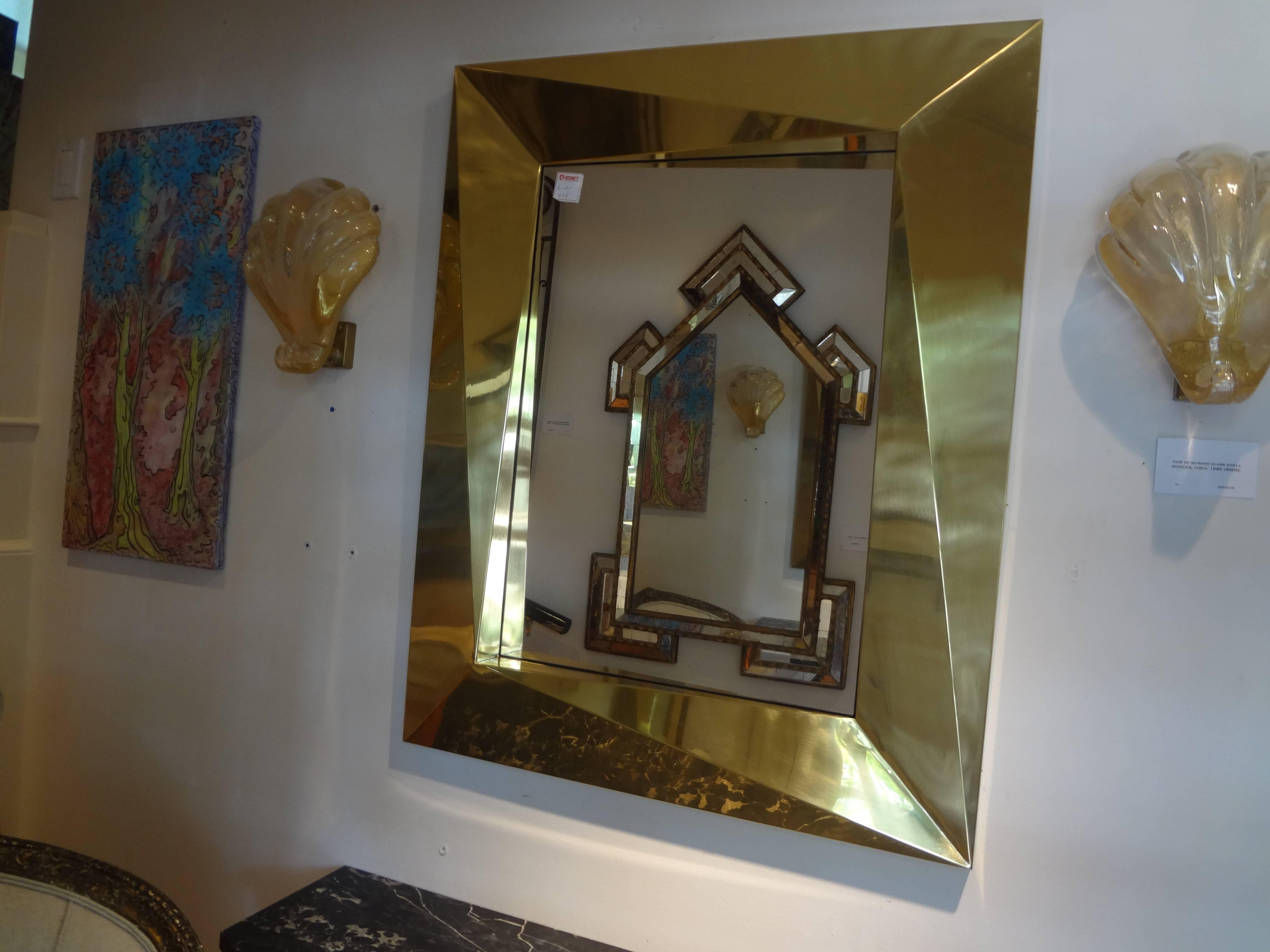 Interesting Italian brass Mid-Century Modern mirror with a 6 inch geometric border, circa 1980. This brass mirror would work well over a console, commode or credenza.