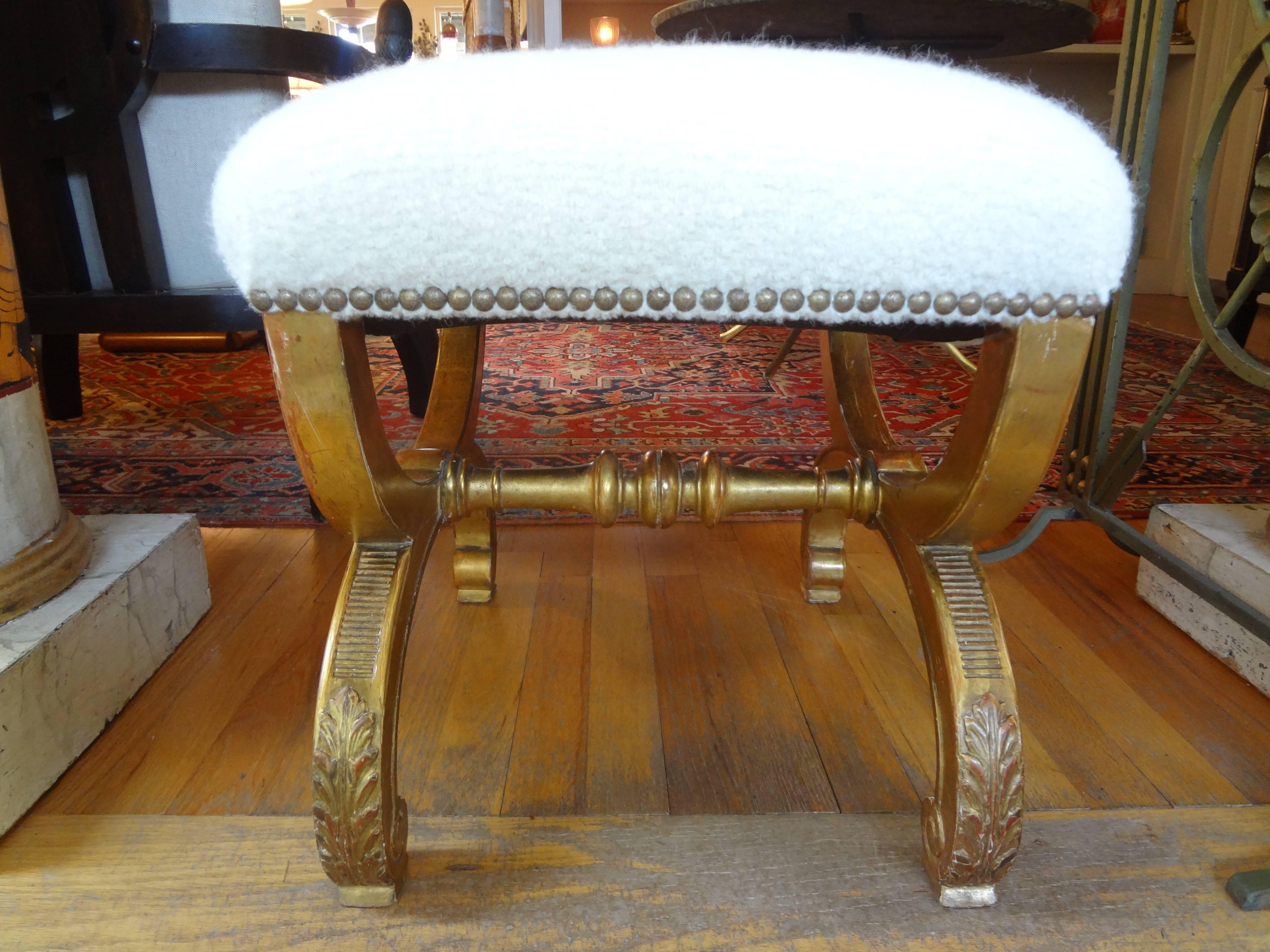 Lovely antique French Louis XVI style giltwood bench, curule stool or tabouret taken down to frame and professionally reupholstered in a white nubby cotton fabric with brass nailhead detail.