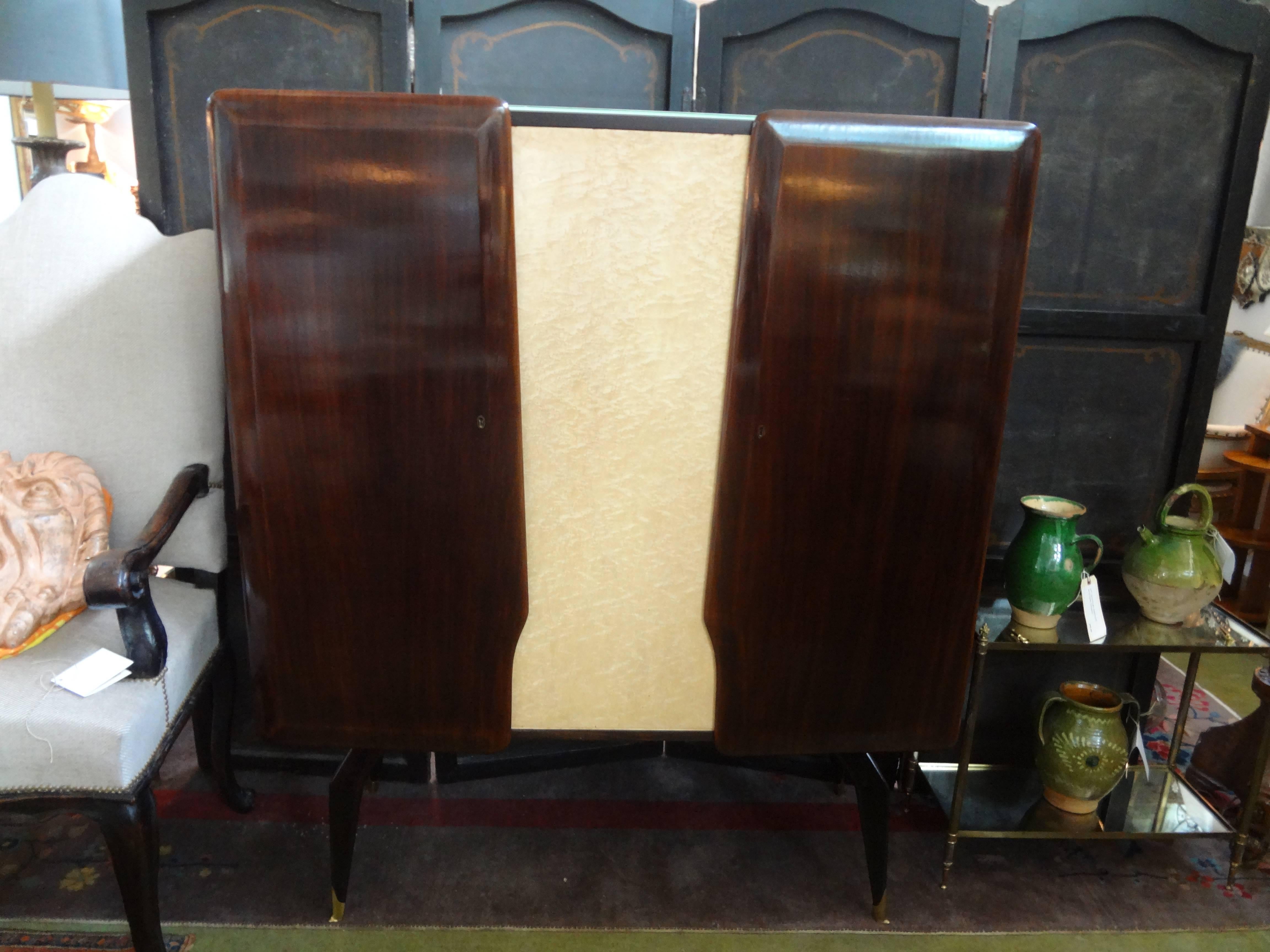 Italian Cabinet or Bar Attributed to Vittorio Dassi.
Italian Mid-Century Modern bar, cabinet, credenza, cupboard or bookcase featuring gorgeous sculpted wood doors divided by a parchment center with a reverse painted glass top resting on splayed