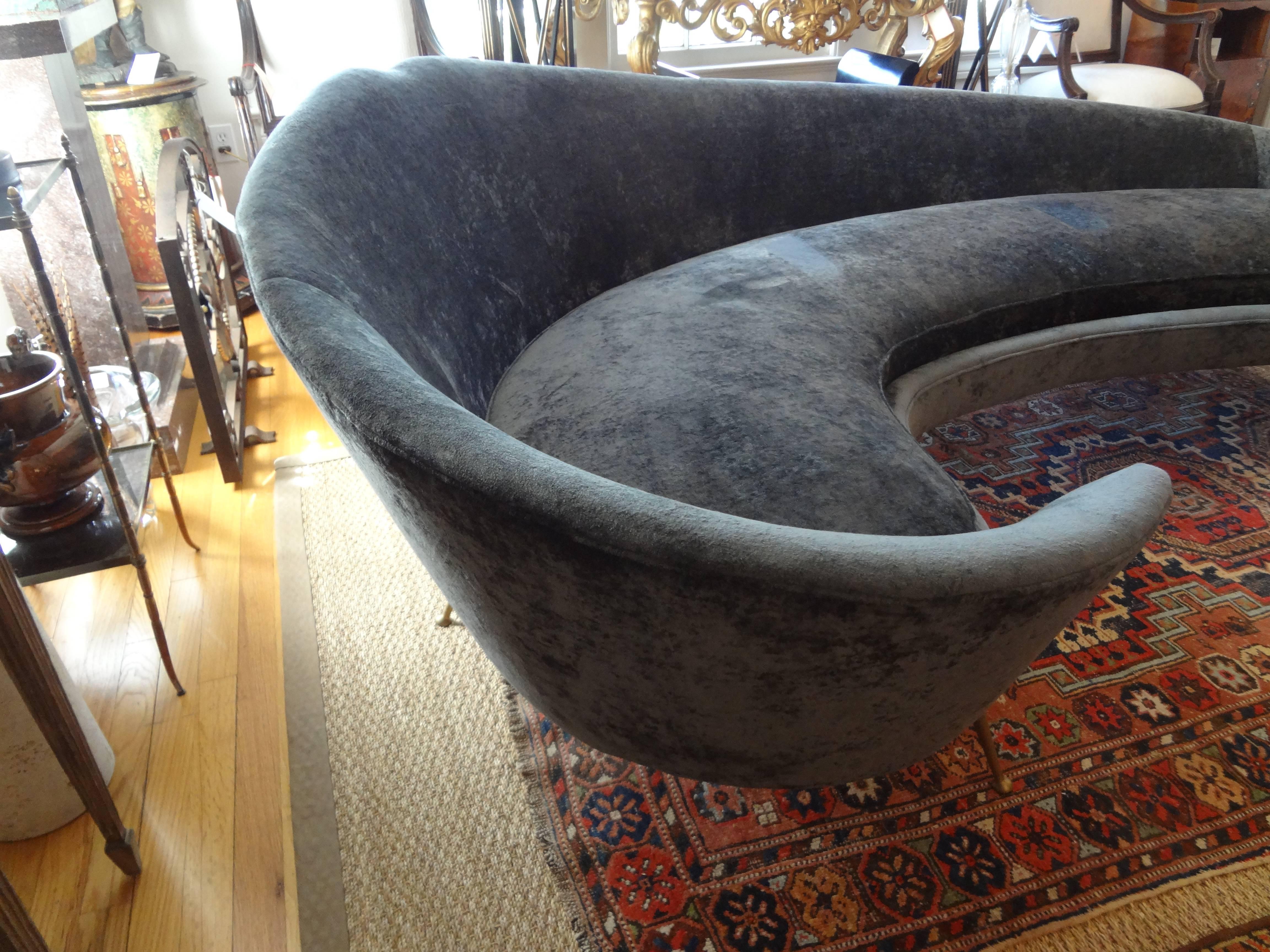 Gorgeous Italian midcentury curved sofa with splayed brass legs attributed to Federico Munari, circa 1960.
Currently upholstered in grey velvet.
The fabulous sculptural sofa is similar to works by artists of the same era in Italy, such as Gio