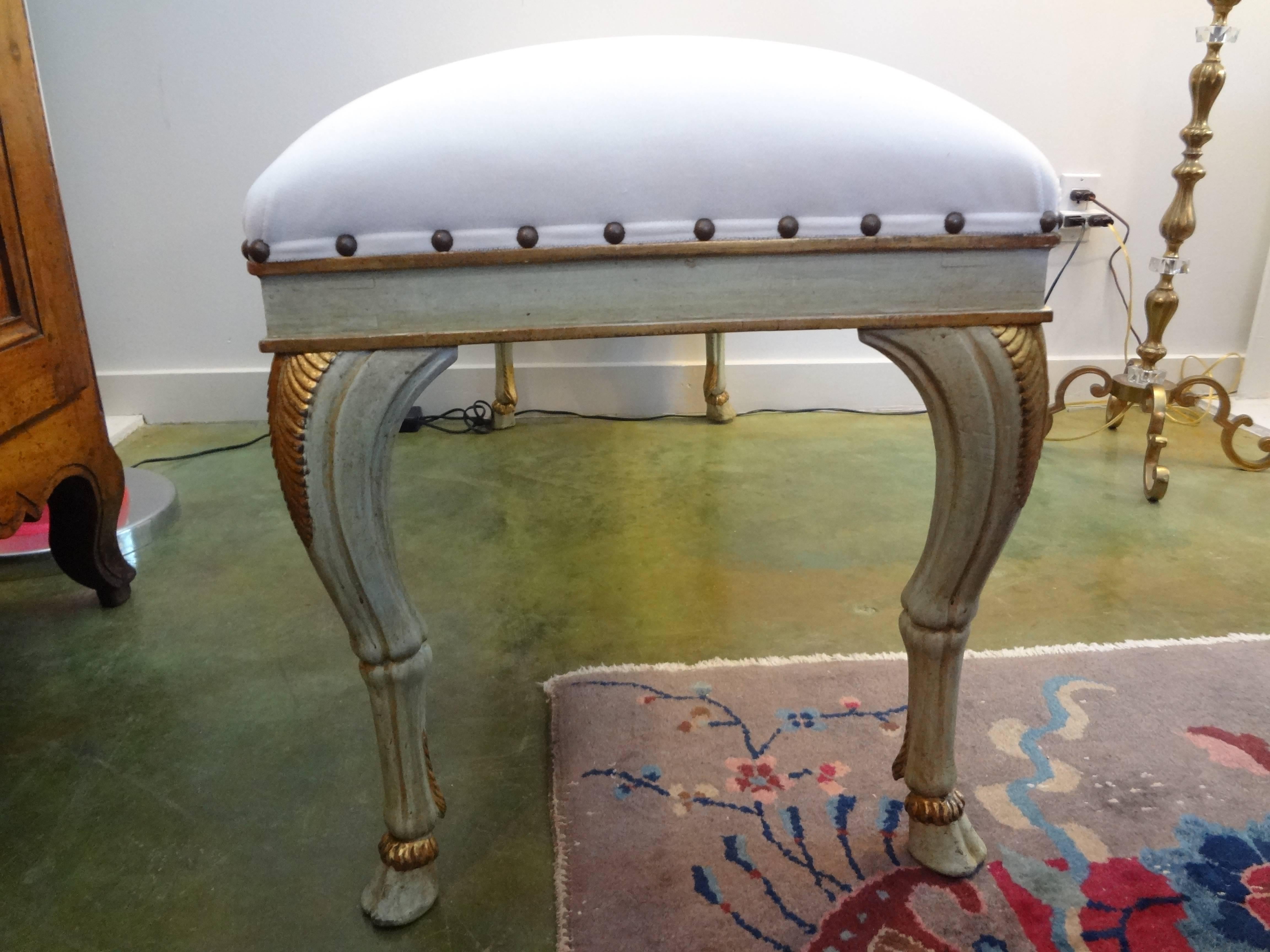 Gorgeous antique Italian painted and giltwood bench with graceful legs and hoof feet. Dates from late 19th to early 20th century. This bench has been taken down to the frame and professionally upholstered in cream velvet with spaced nail head