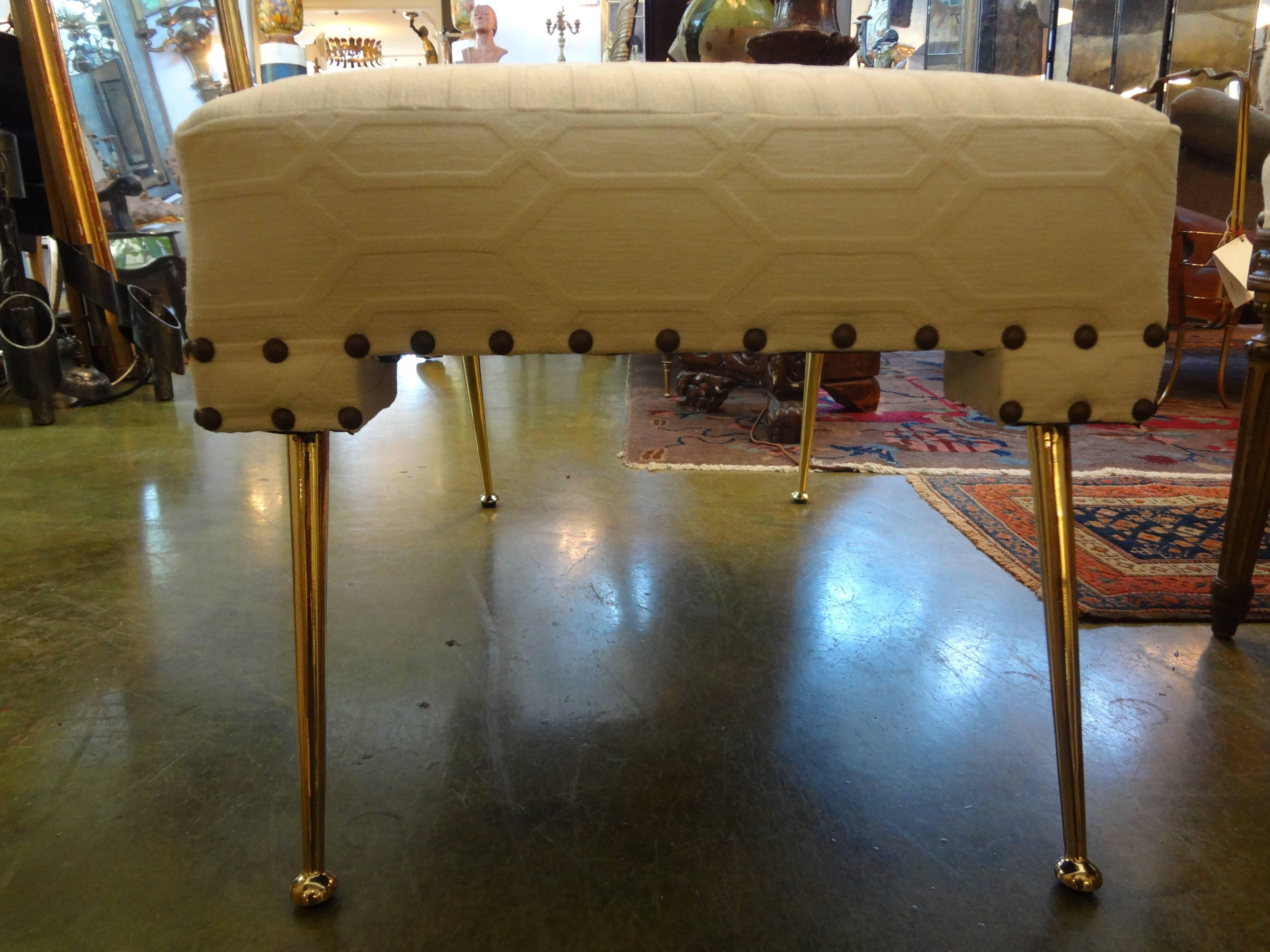 Stylish pair of Italian Mid-Century Modern Gio Ponti inspired benches or ottomans with brass splayed legs. These ottomans/benches were taken down to the frames and professionally upholstered in cream colored textured velvet with brass nailhead