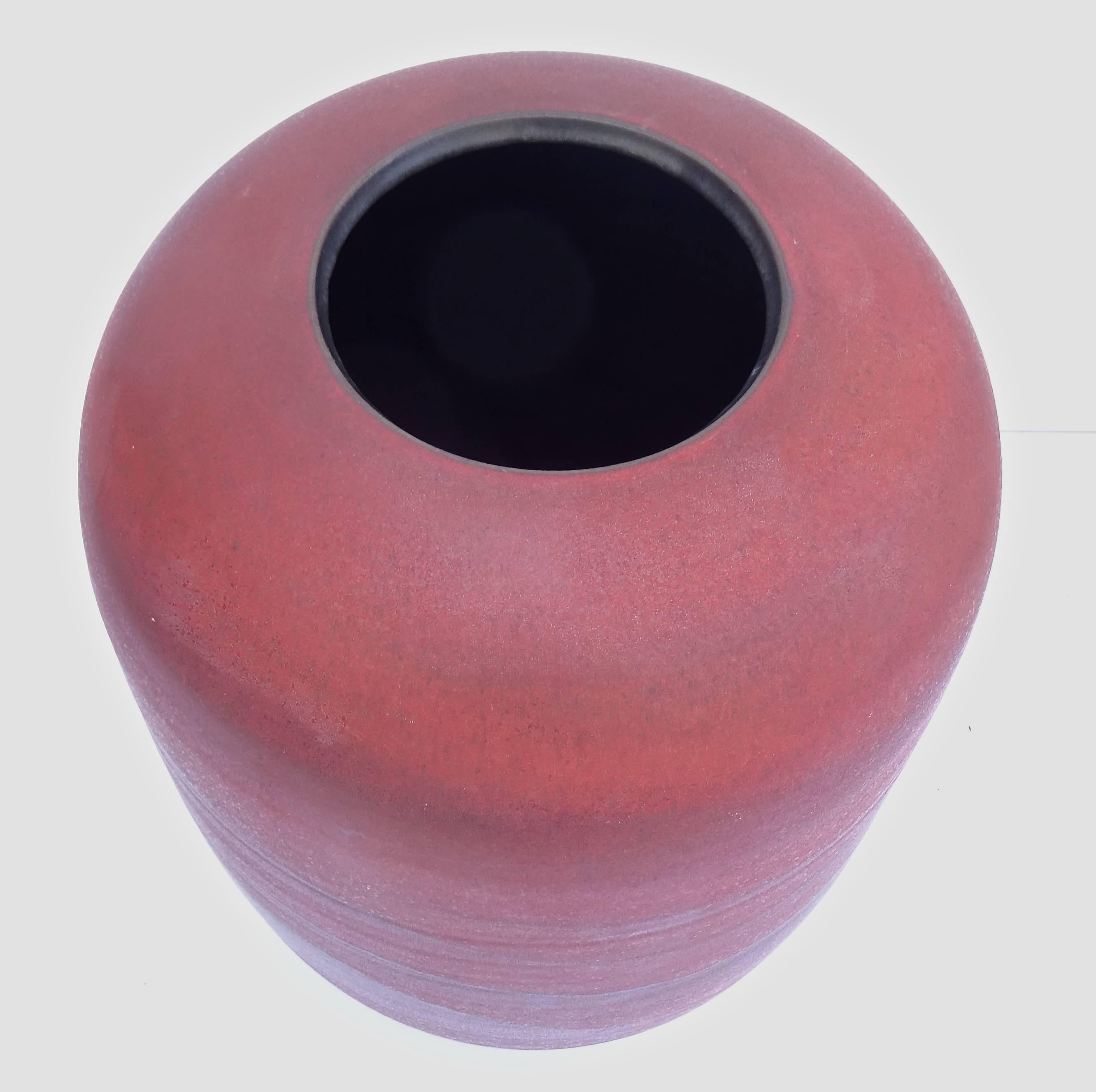 Fabulous hand thrown large scale vase, Germany, 1960's, with a deep complex tomato red matte glaze and gorgeous amorphous horizontal black decoration which evokes a skyline or horizon.  Interior has a black glaze.  Signed illegibly on the bottom, so
