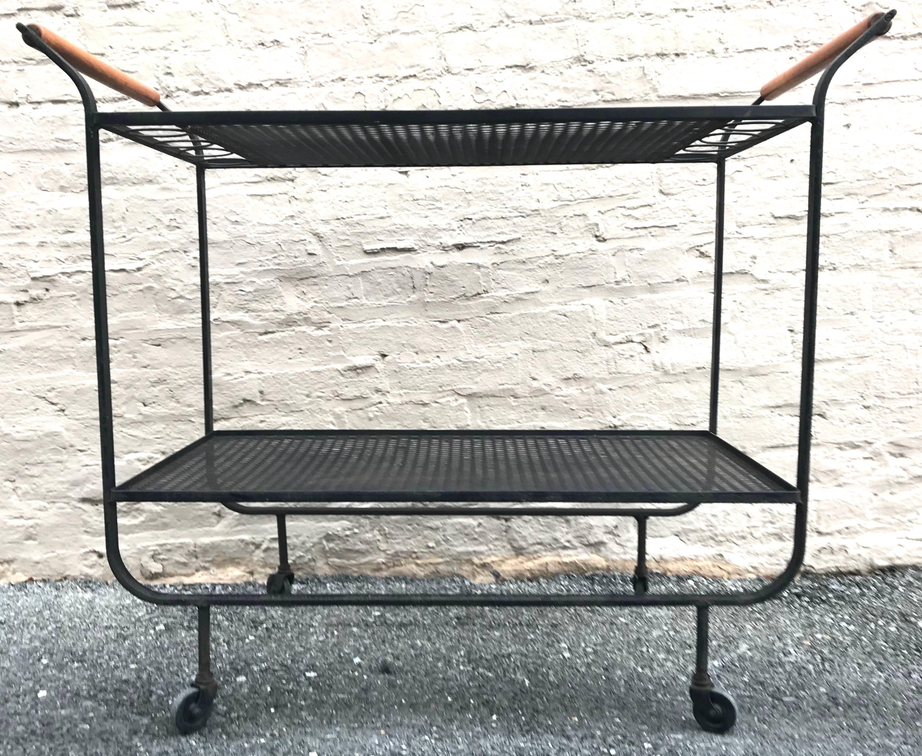 Rare early 1950s American modernist Frederick Weinberg wrought iron bar cart with wood handles. Graceful, elegant late Art Deco inspired design.