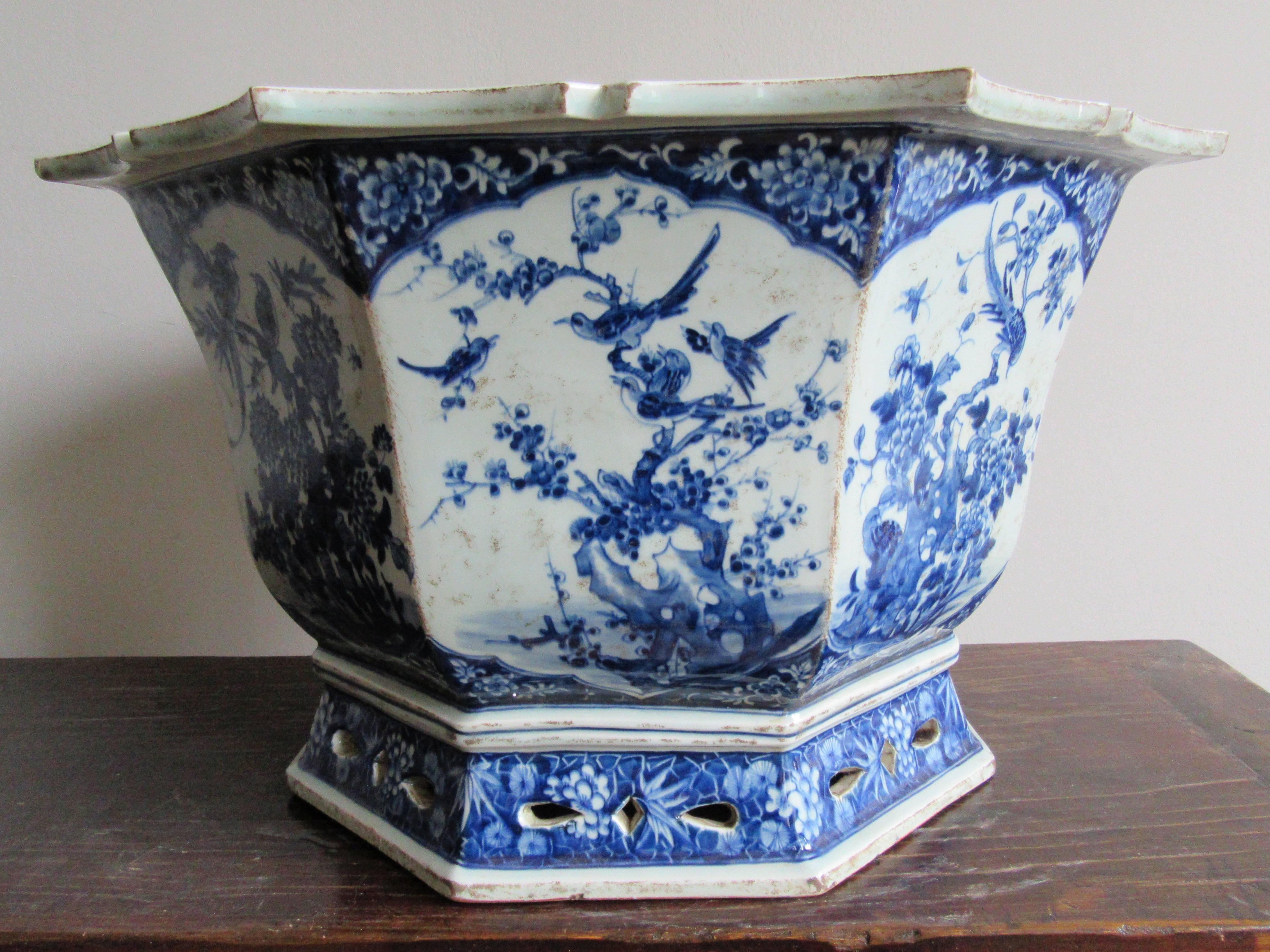 Imposing Chinese blue and white porcelain jardinière/planter. Octagonal in shape each panel is expertly hand painted with a unique floral and aviary motif. The floral paintings depict chrysanthemum, plum blossom, and peony and the bottom has a