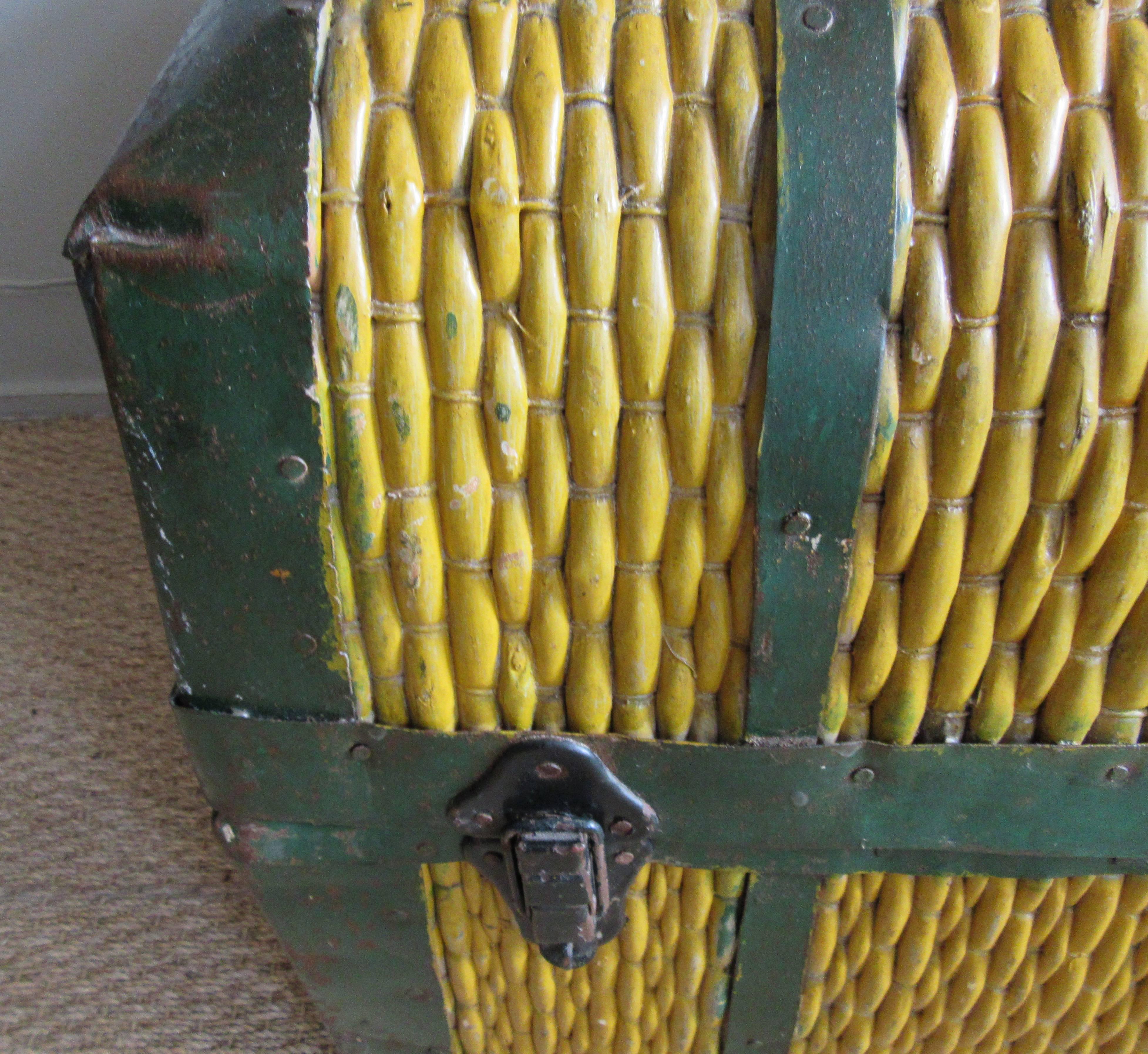 Vibrant saffron yellow rattan trunk with old fashioned curved top accented with green metal fittings. The woven rattan is stretched over a sturdy and hard wooden frame. A stunning accessory for a rustic interior.