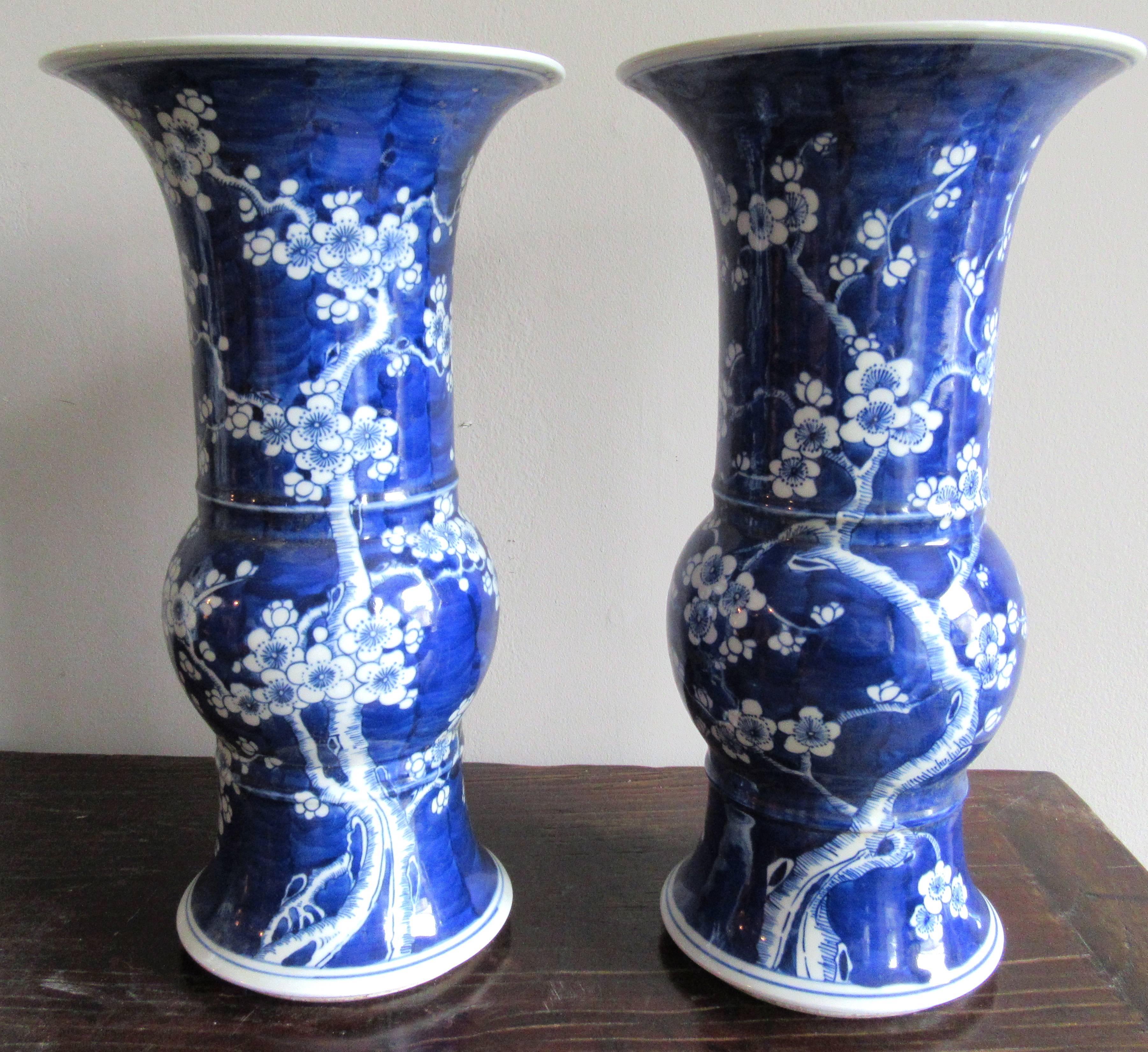 Pair of Chinese porcelain baluster shape vases with cherry blossom motif on a vibrant indigo background.