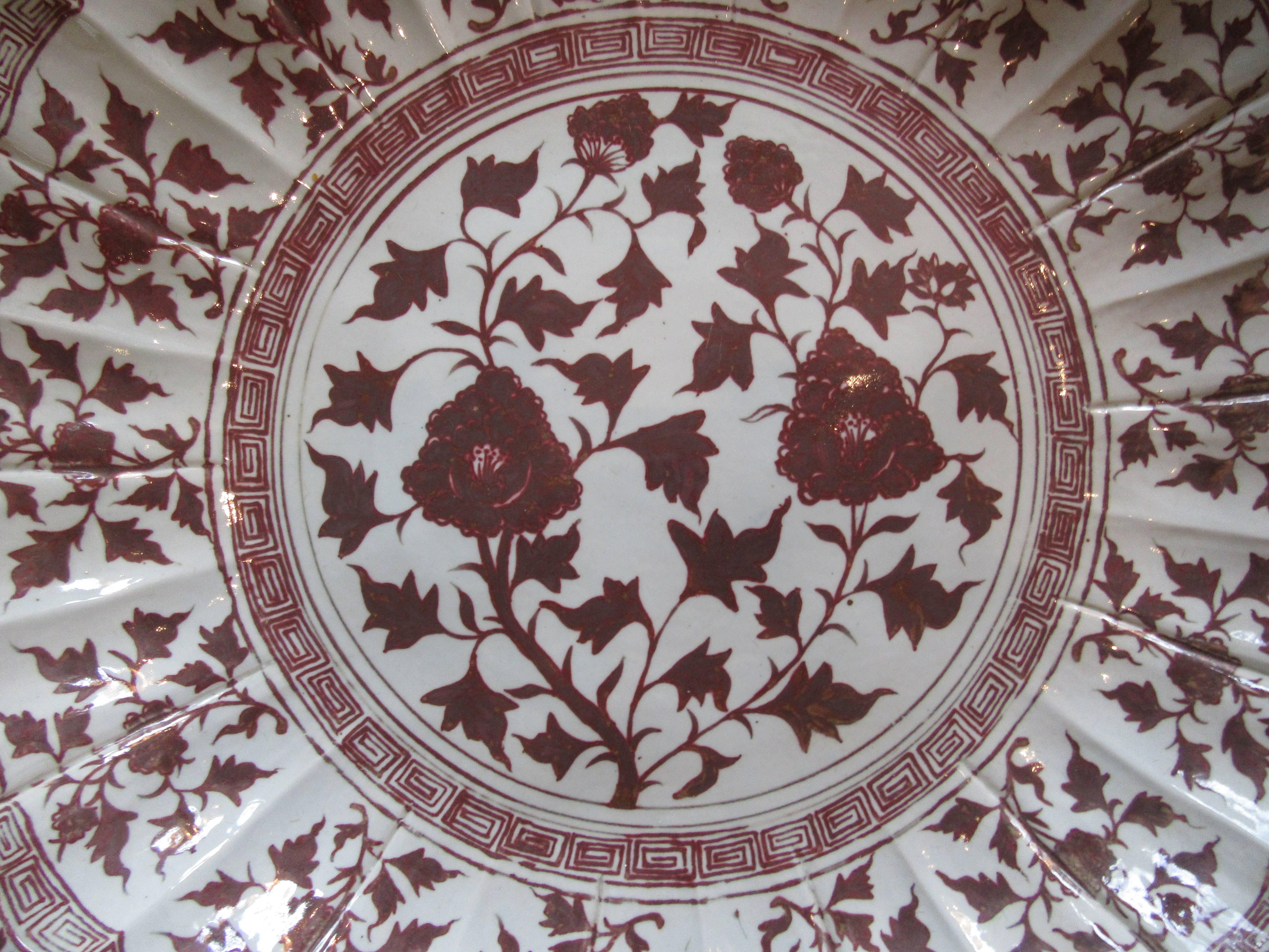 Monumental Chinese red and white porcelain charger hand-painted with a floral motif. This impressive piece is enhanced by a scalloped edge in the Ming style.