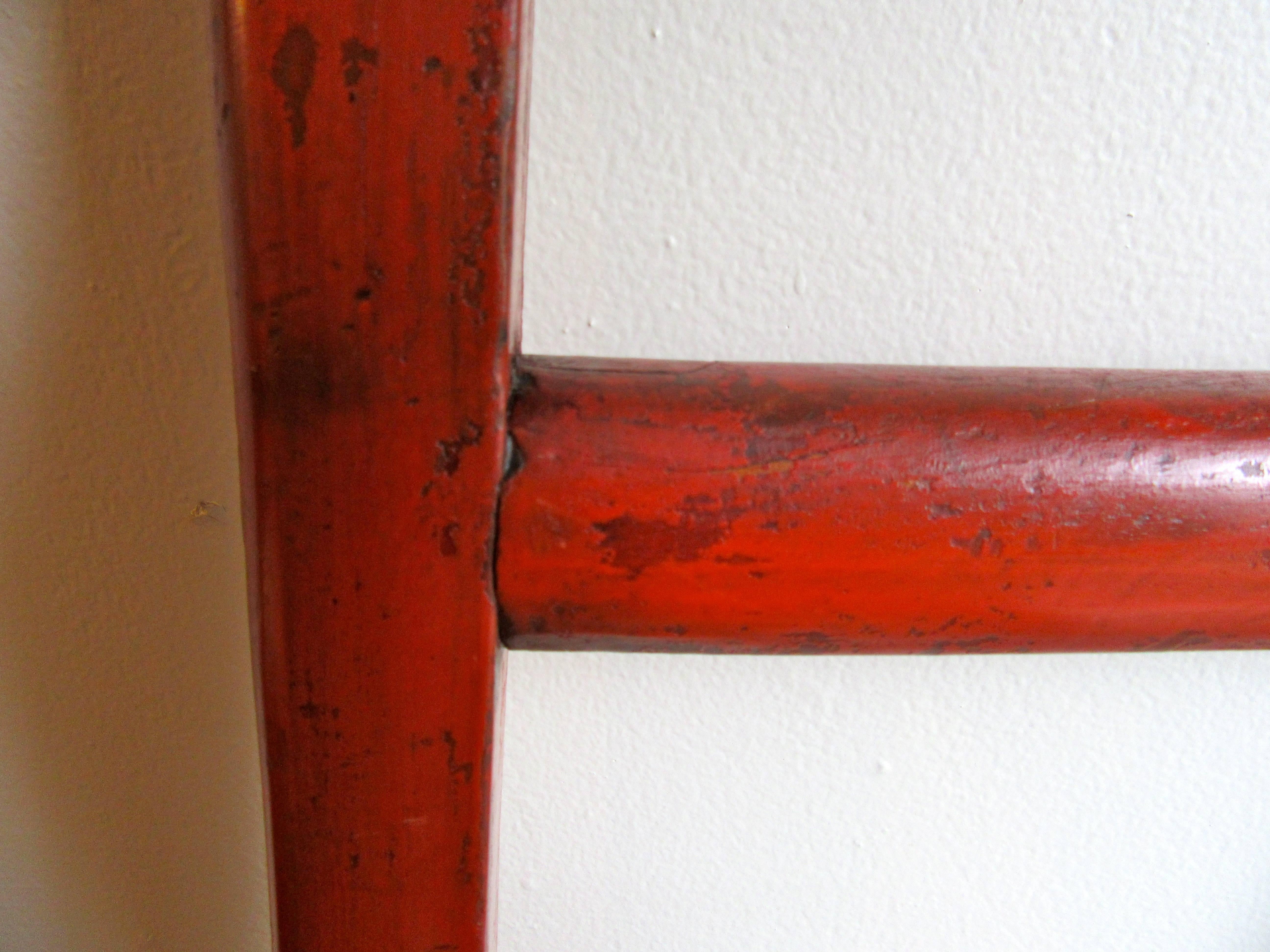 Ladder with charming carved top in red lacquer finish.