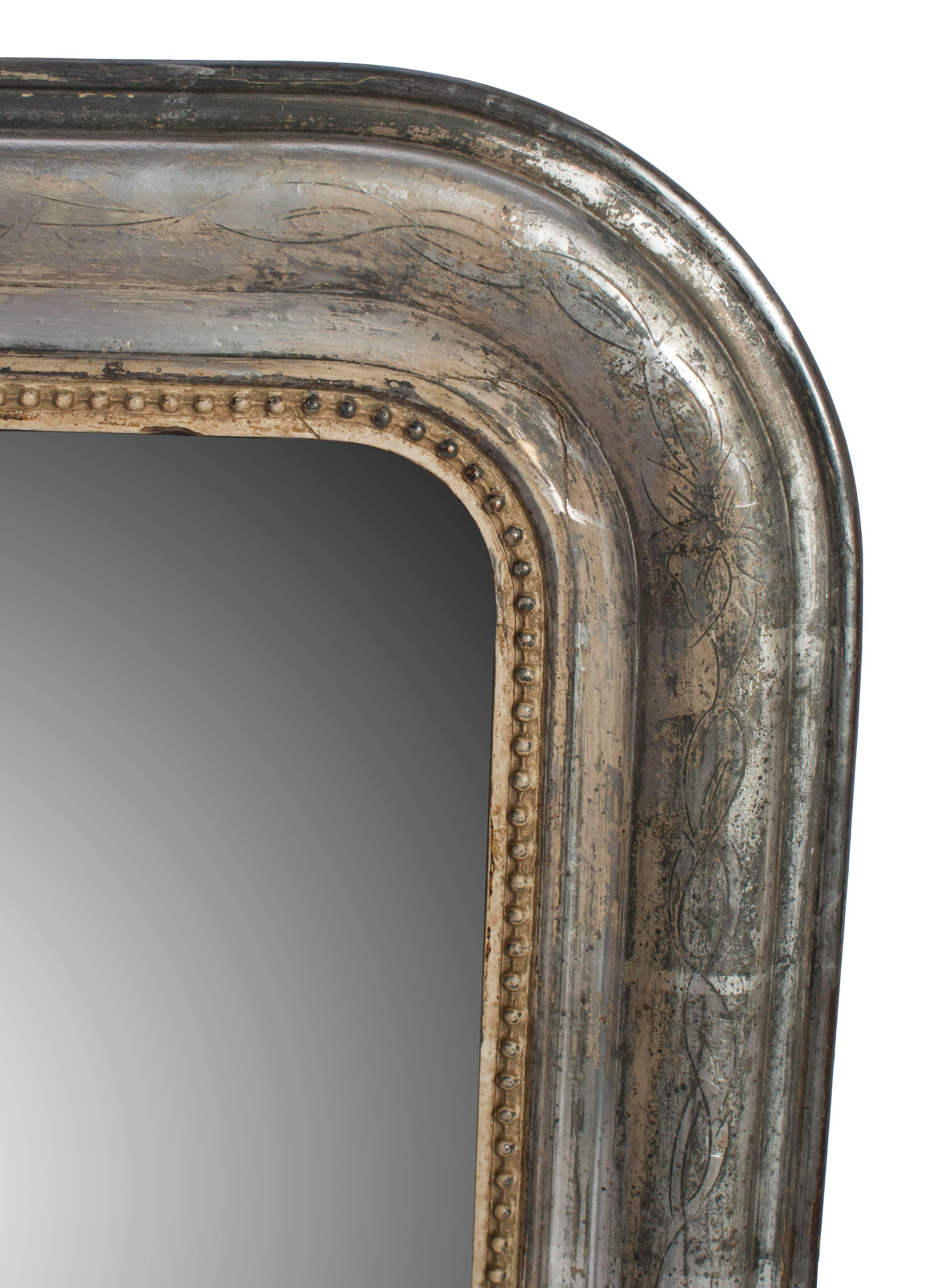 A small silver frame mirror with gold bead trim.