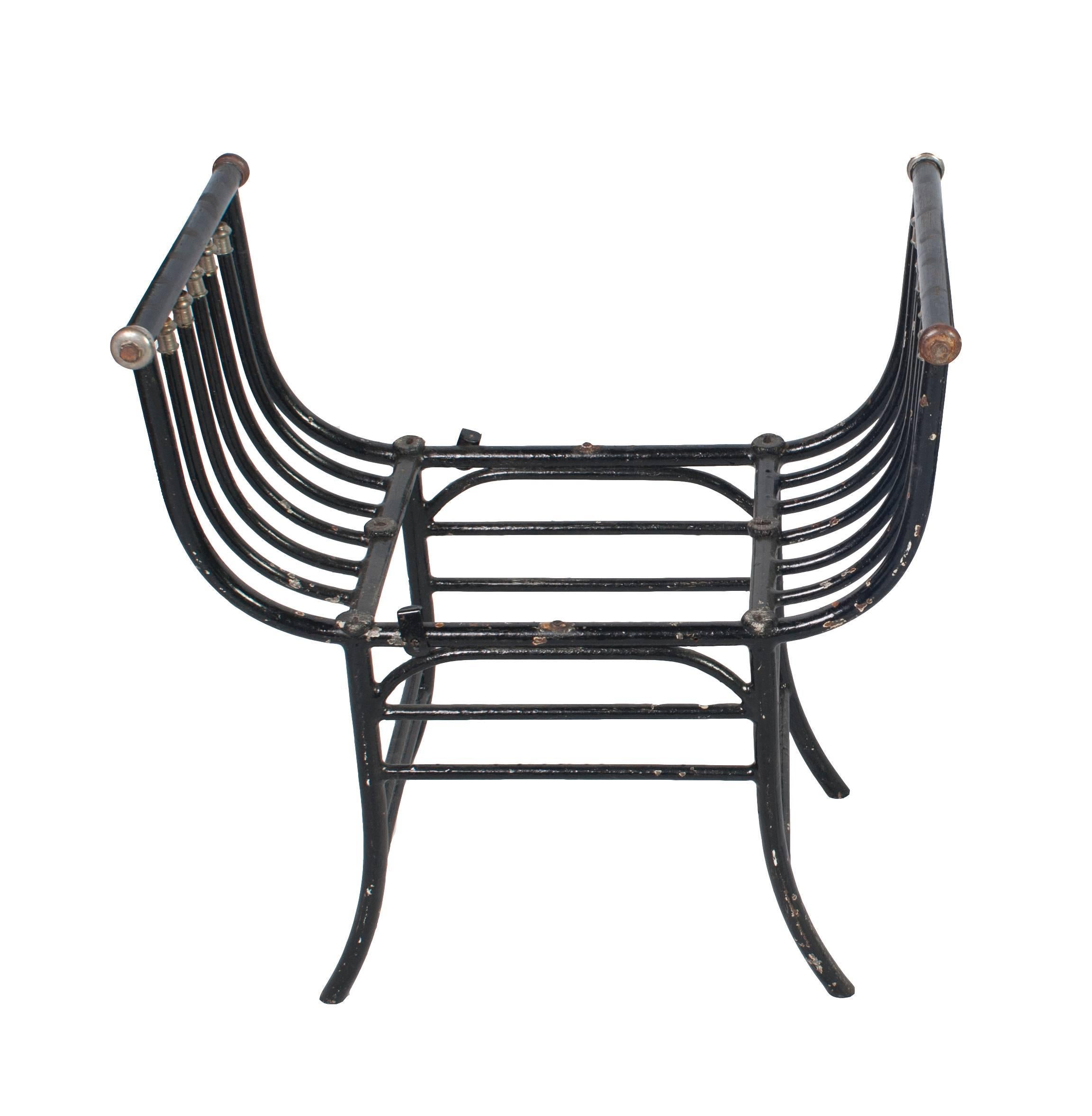 A pair of black painted wrought iron window seats or stools.