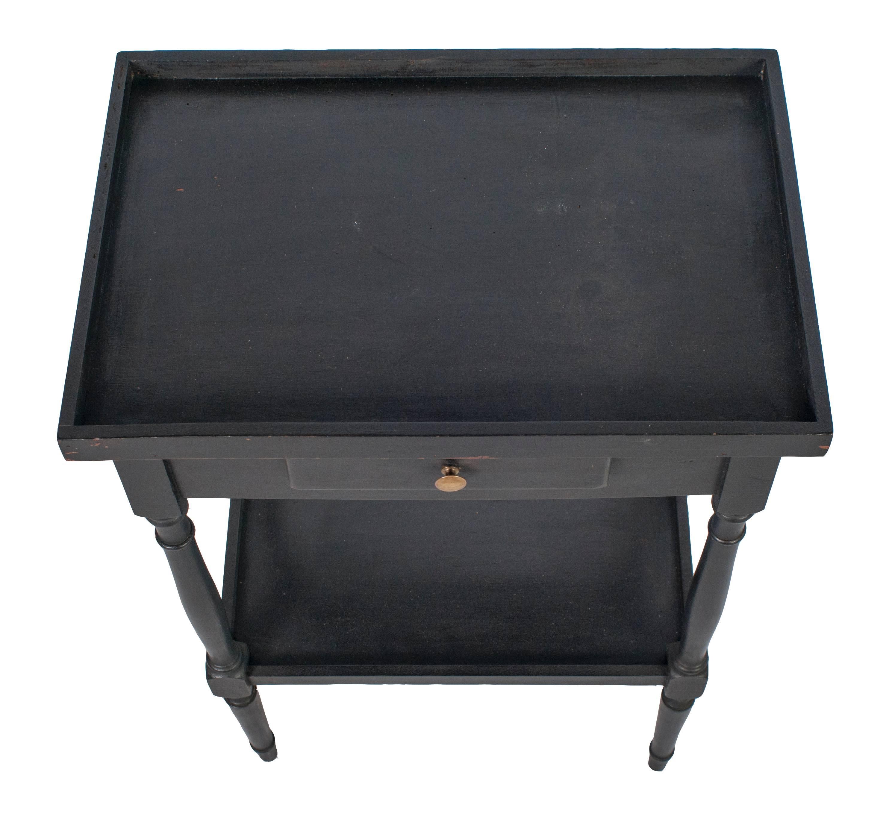 A pair of black painted nightstands with a drawer and shelf.