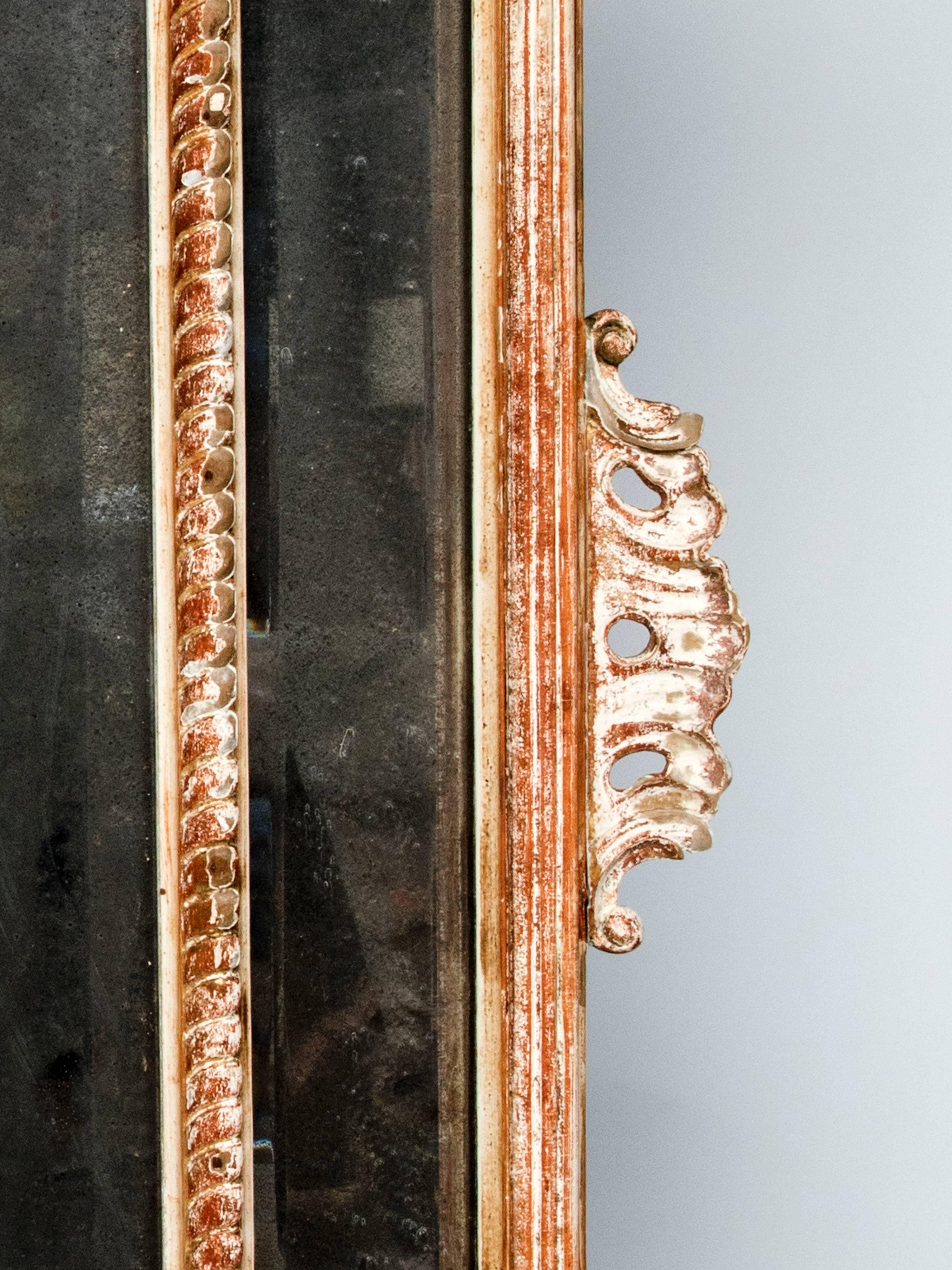 Un très beau grand miroir en bois sculpté, le miroir lui-même est très dépoli.
Superbe coquille sculptée au sommet, très décorative.
La feuille d'or dans certaines parties est usée.