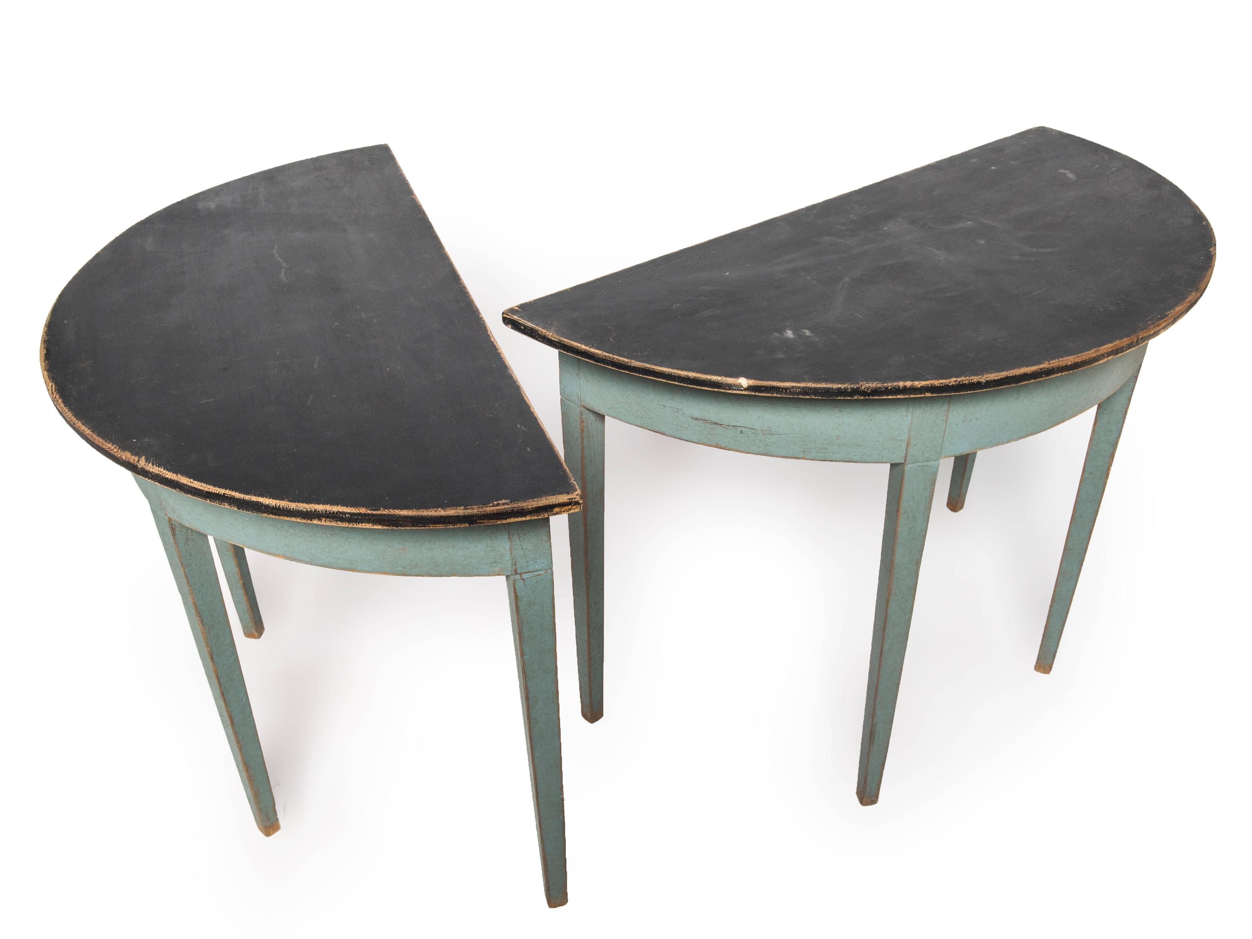 A pair of blue painted demilune tables.
