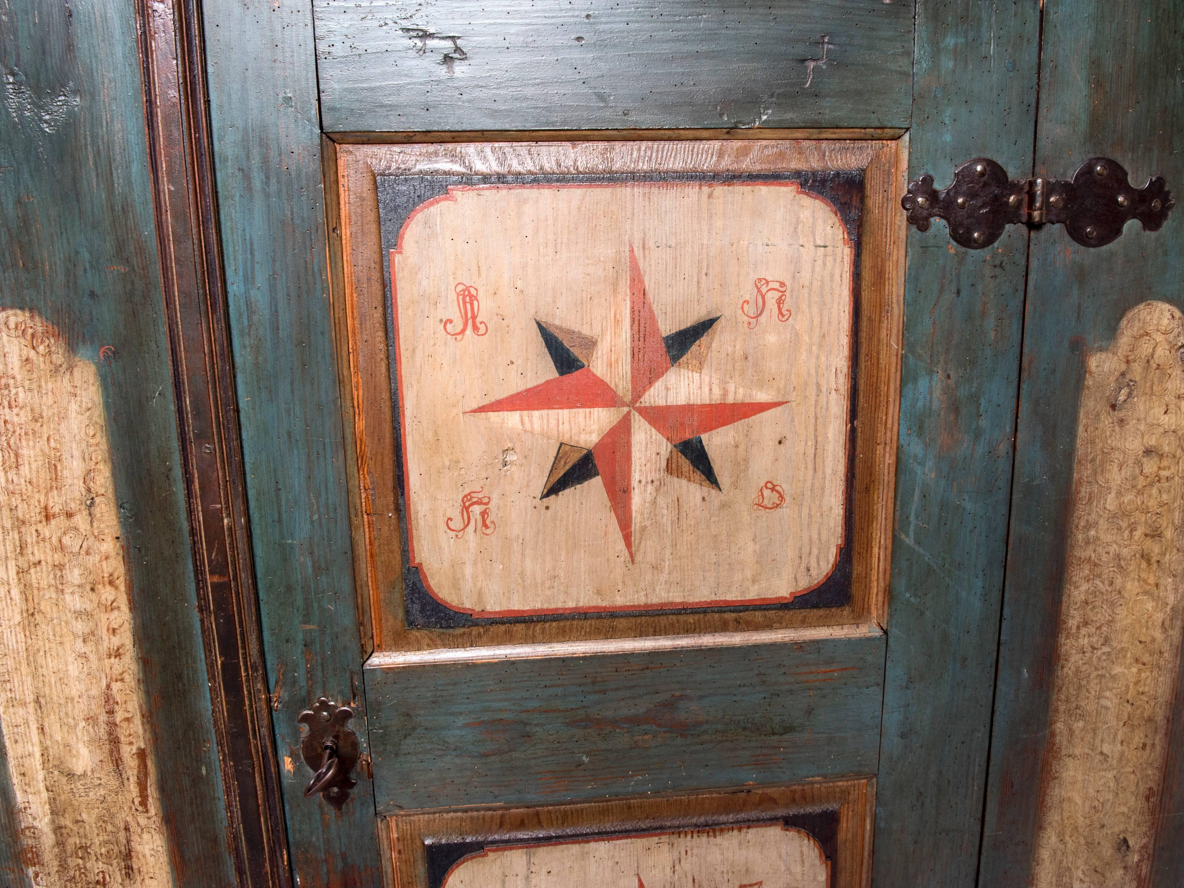 This is a very nice original hand-painted Bohemian Armoire. The outside is hand-painted in a green color with hand-painted stars to the door in a cream color. We have the original key with a heavy duty lock in working order, the hinges are also