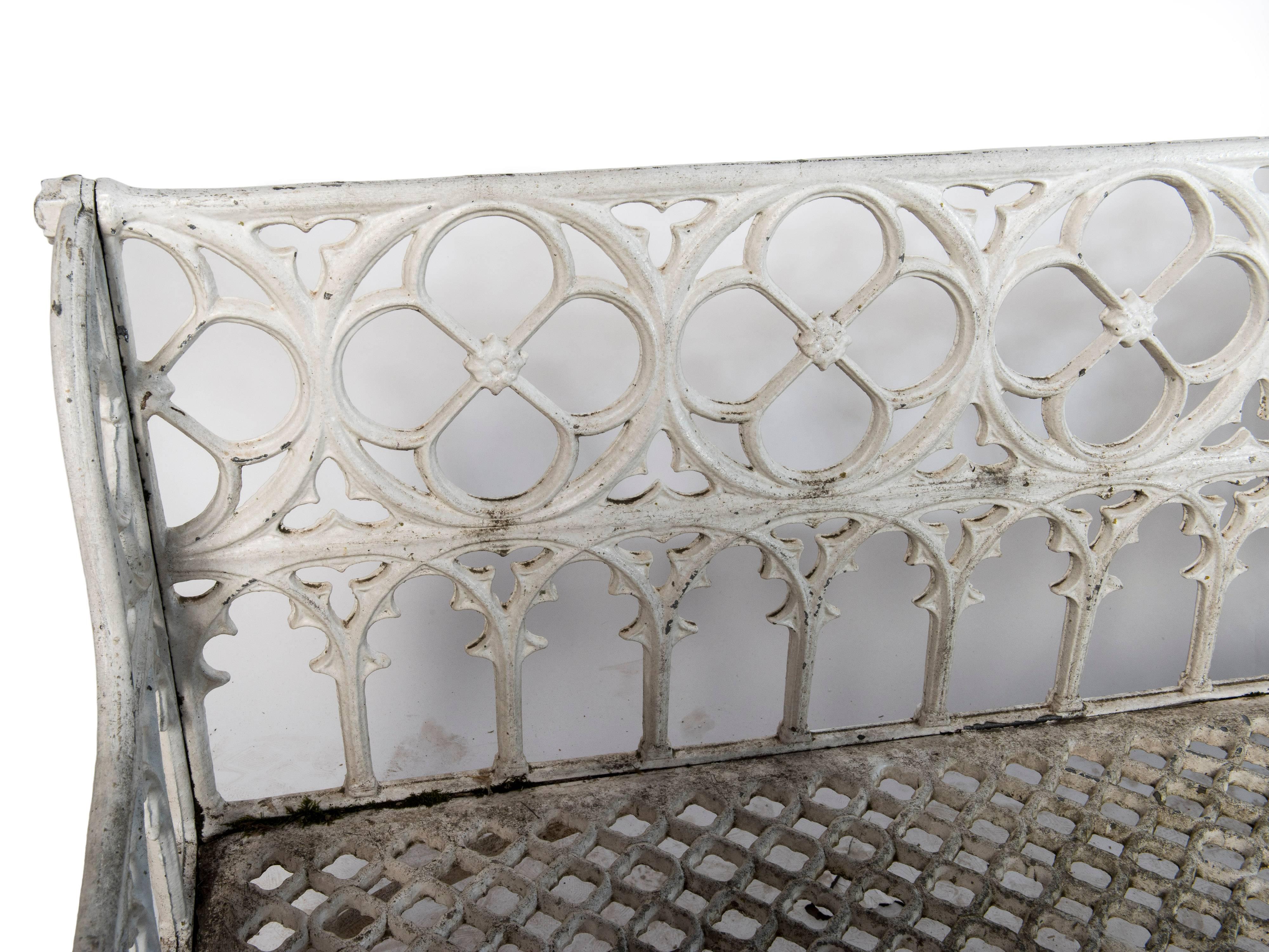 A white painted cast aluminum Gothic bench.