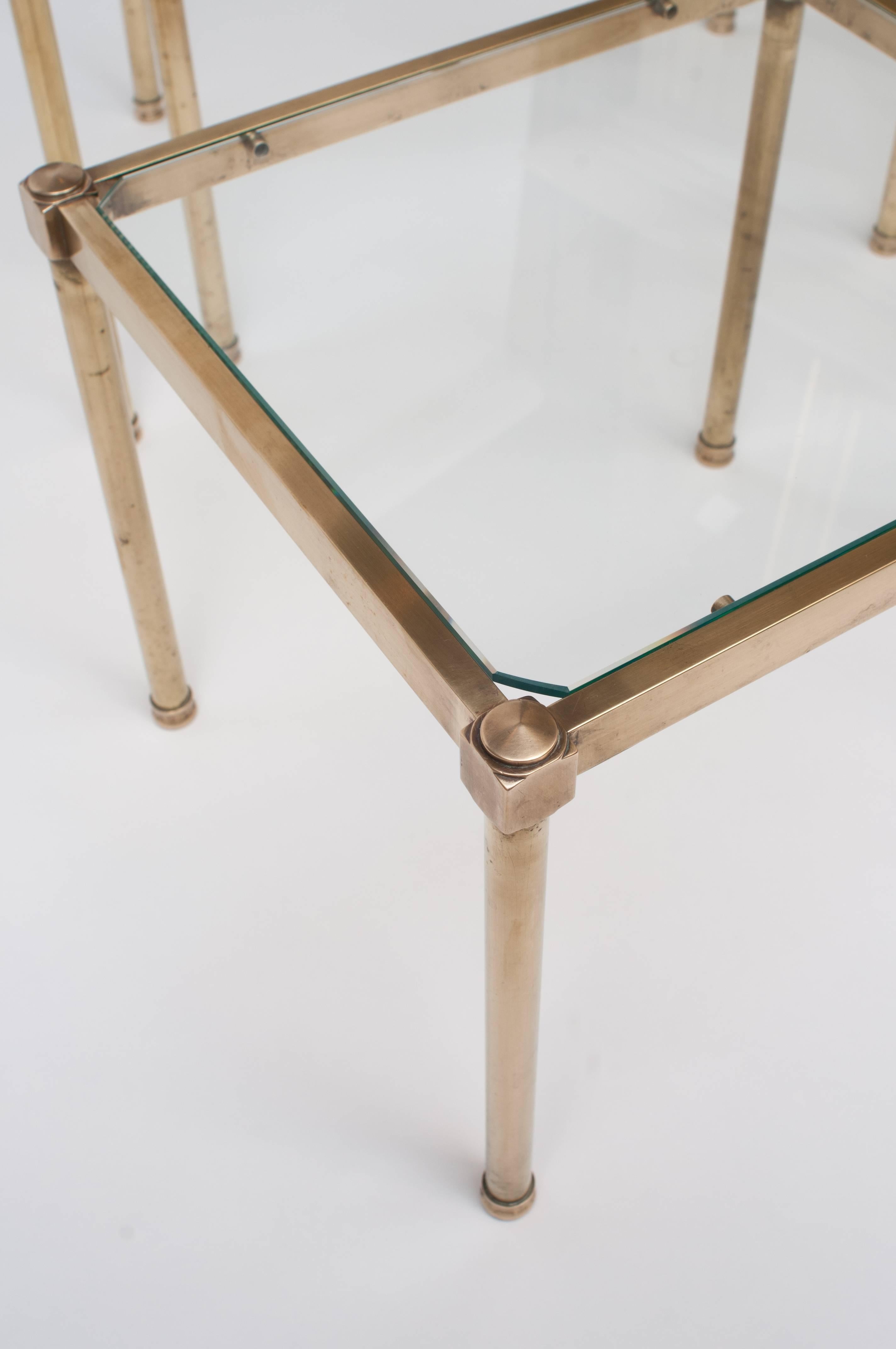 Finely cast brass with inset glass tops. Glass has canted corners. When separated they make excellent small side tables. Measurements: smallest: 15.75" long x 13.75" deep x 13" tall; medium: 17.75" long x 13.75" deep x