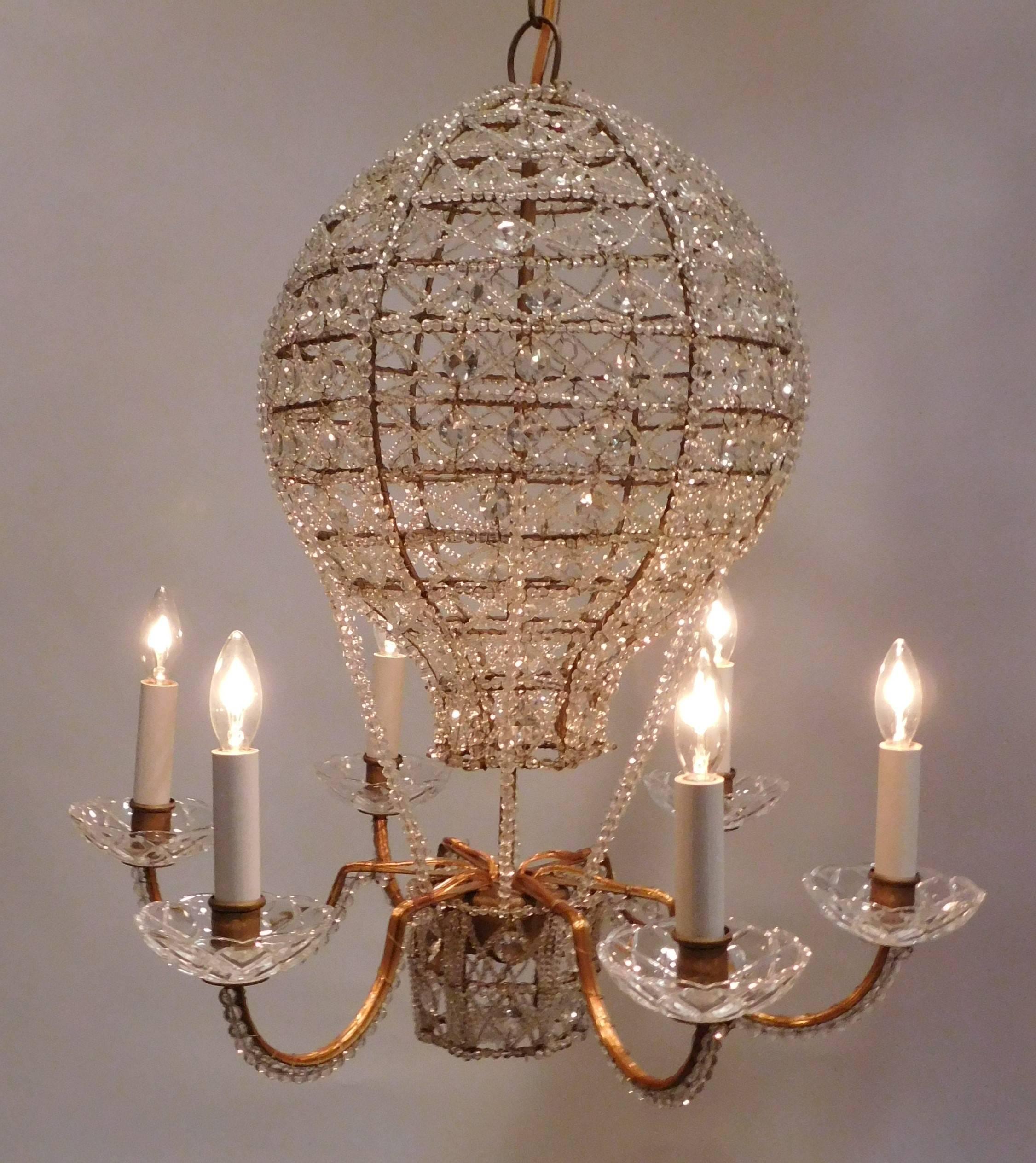 Six lights with hand-cut and hand-beaded crystals over gilt metal frame includes chain, hanging hardware and ceiling cap.