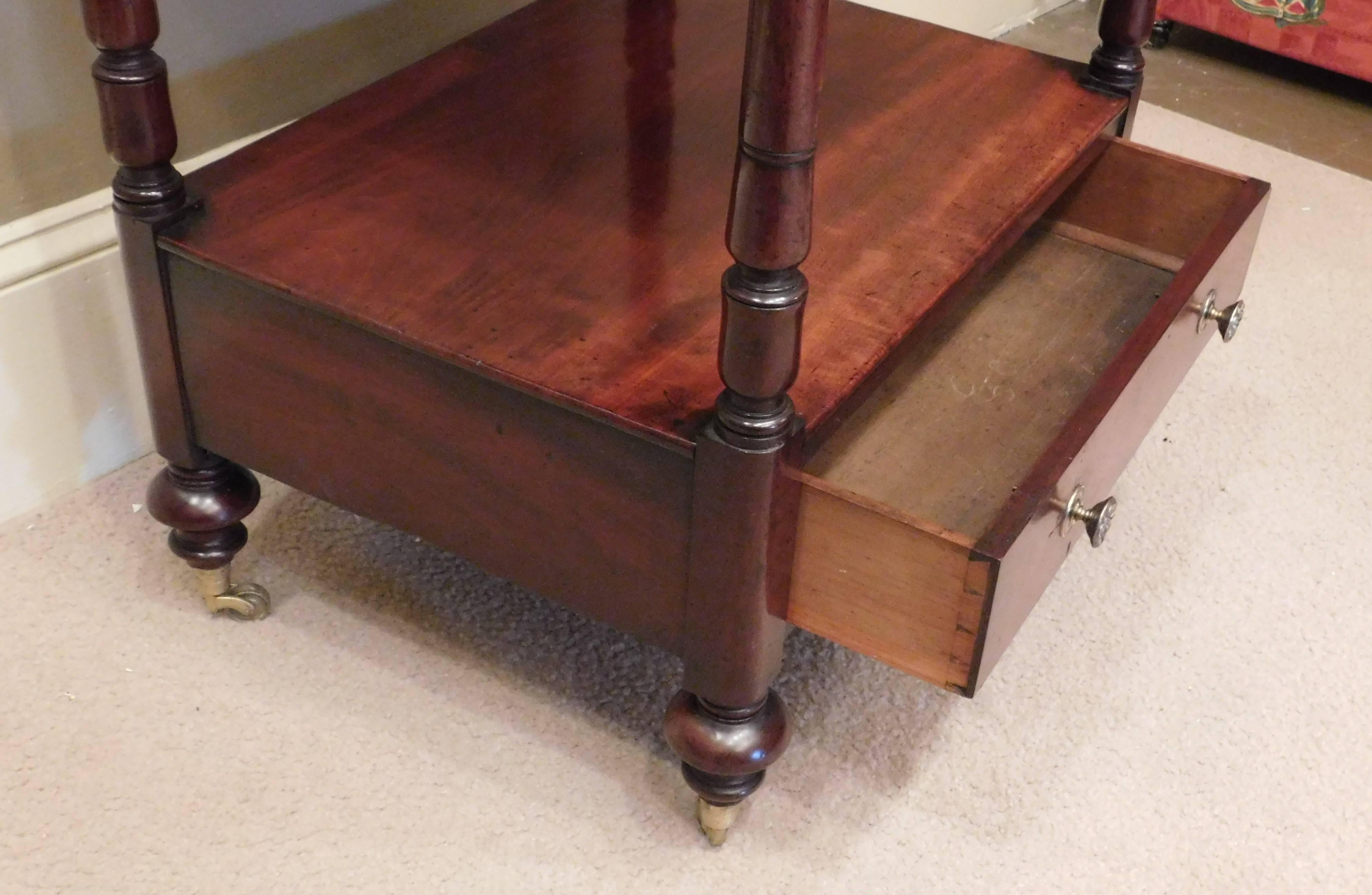 Mahogany with oak secondary wood French polish one-drawer casters appear original bottom shelf height: 12"; top shelf height: 27.75"; total height at corners: 28.5".

   
