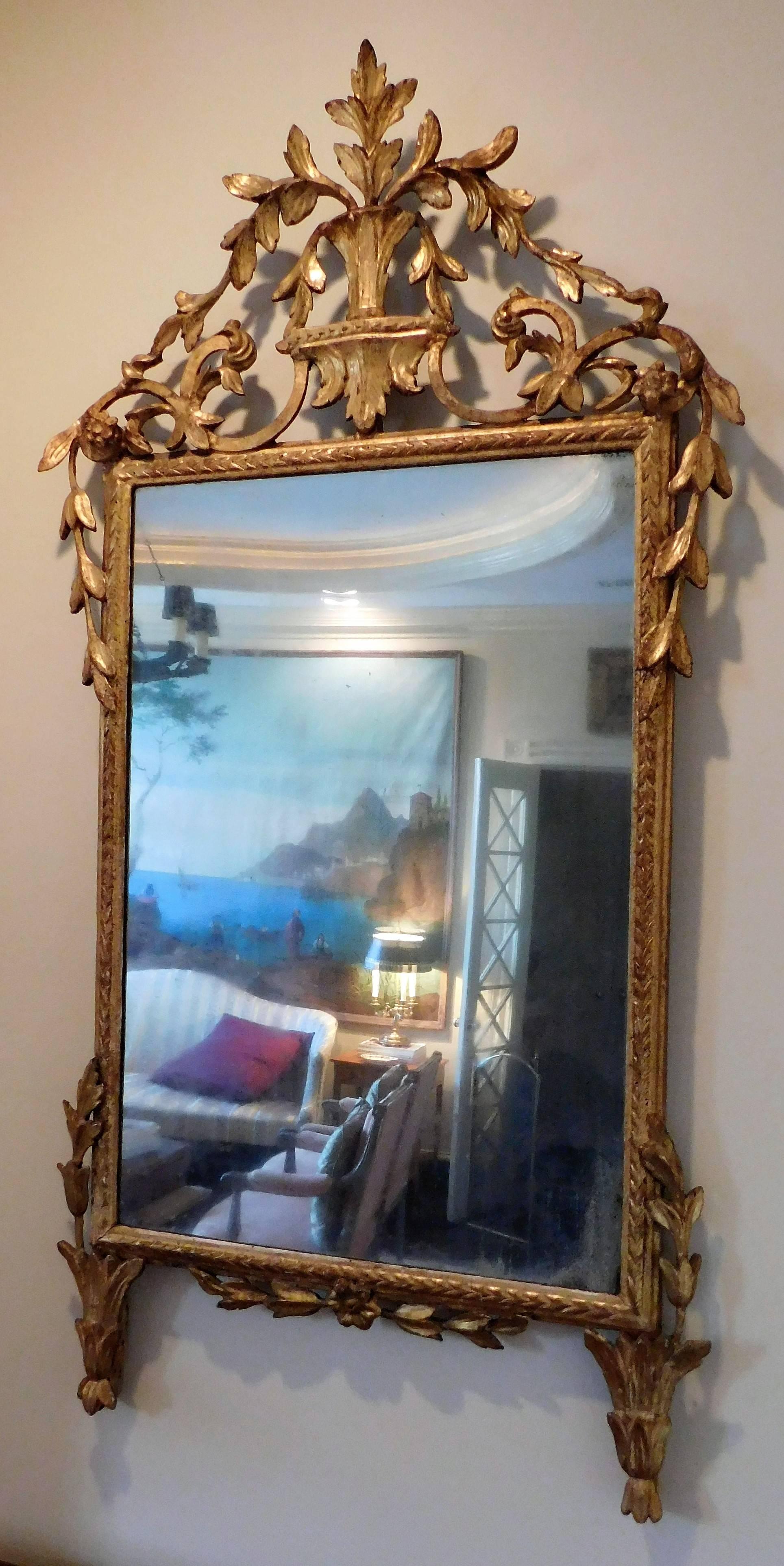 Probably made in Florence. Gilt and gold leaf on gesso on wood. Original wooden back. Mirror appears to be original. Excellent hand-carved foliate design.