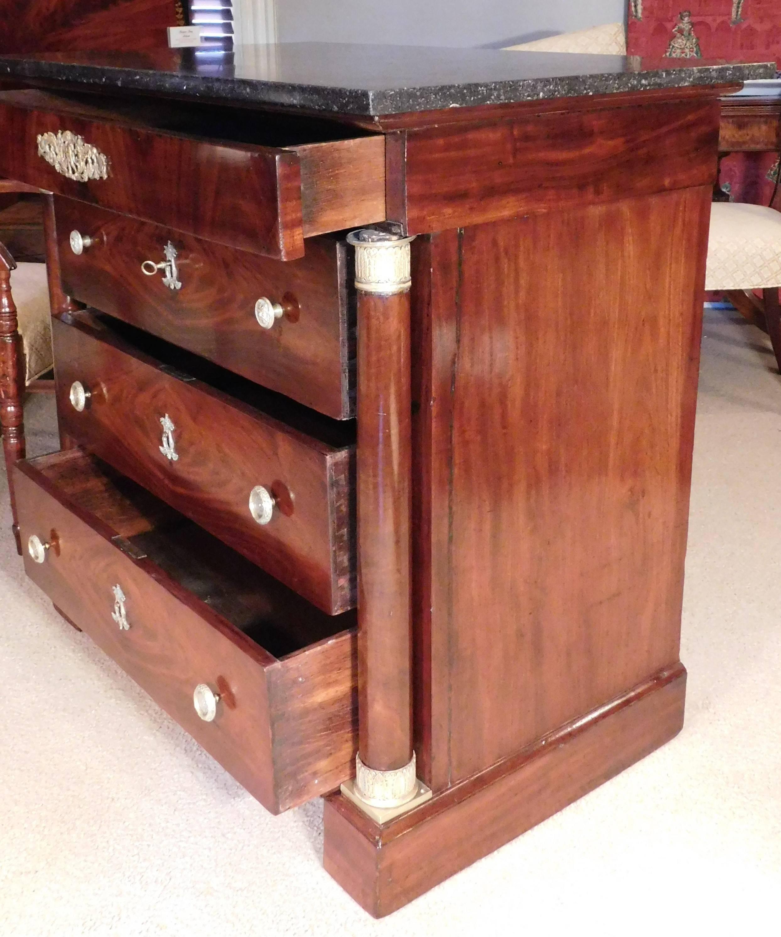 Mahogany and mahogany veneer with oak secondary wood. Finely cast bronze ormolu mounts and pulls. This chest has a narrow drawer over three large drawers. Stone top appears to be original with rear overhang.