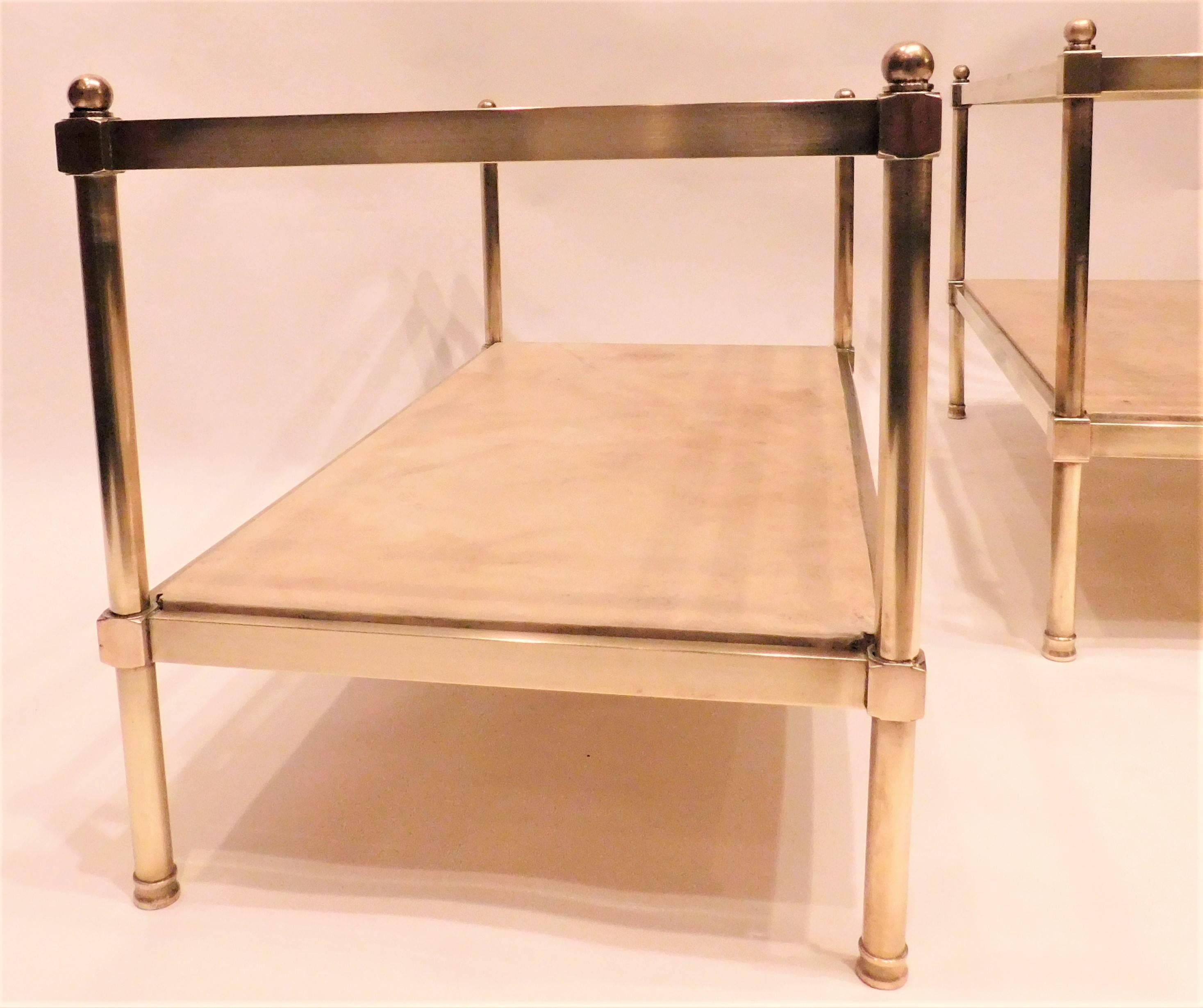 Solid brass with glass tops and parchment lower shelves - neoclassical design. These tables are identical in size except one is one inch shorter than the other (+/- 1/2 inch from height shown). There are some other slight variations between them --