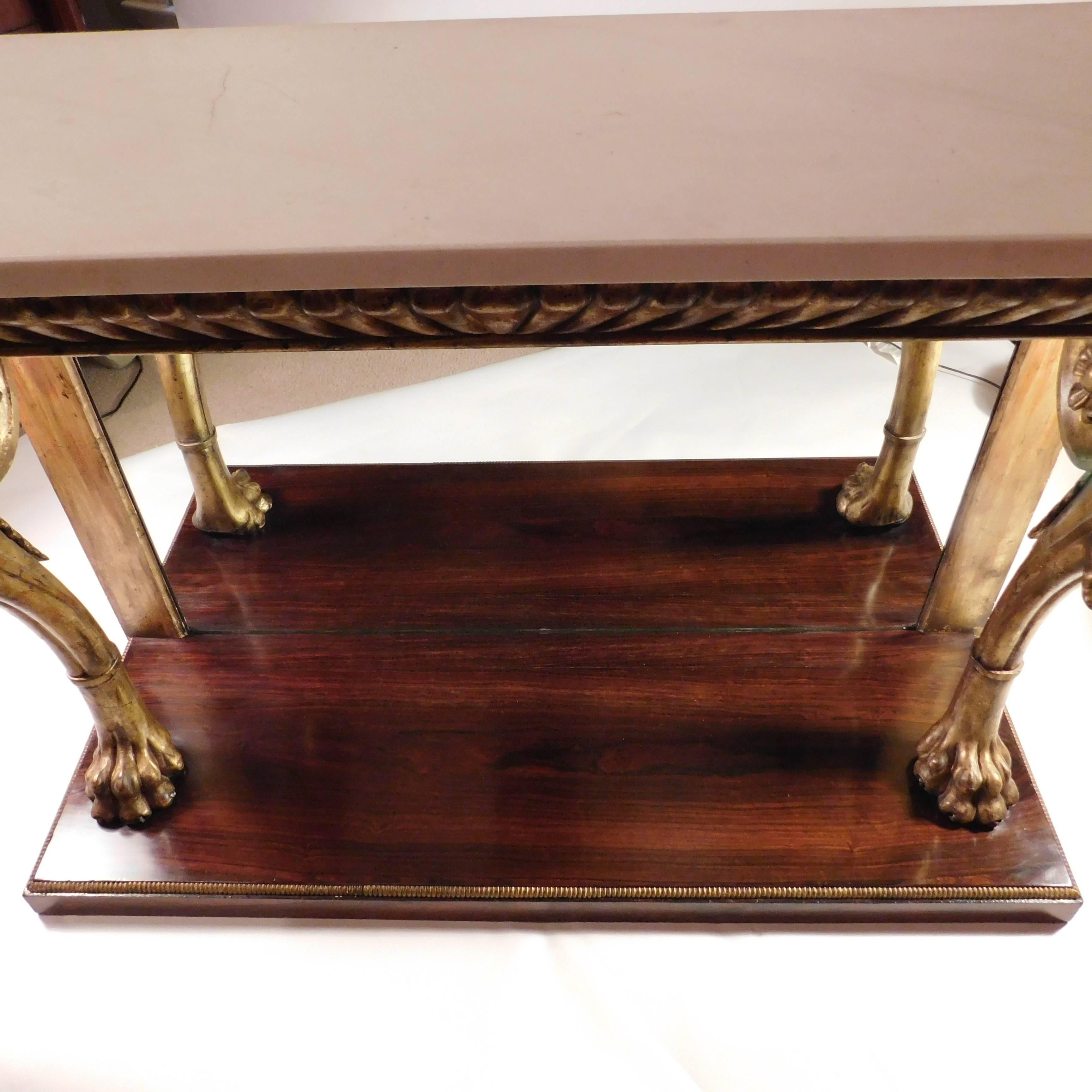 This oversize pier table or console is gilt and paint on hand-carved wood with a white marble top and a mirrored back. Top supported by gracefully scrolled and curved legs above lion's paw feet. Gadrooned border around the top skirt and, in smaller