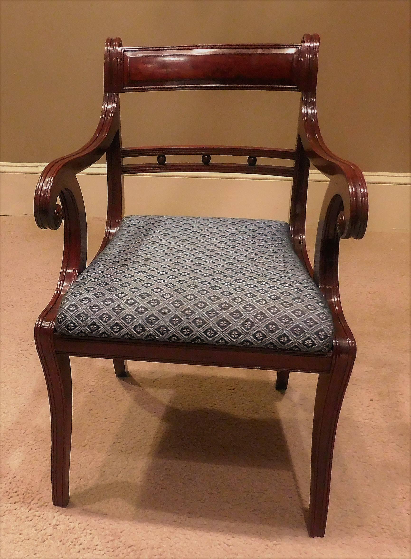 This set of 12 federal era chairs is comprised of two armchairs and ten side chairs. French polished mahogany frames have slip seats, eleven of which are covered in woven horse hair. Finely reeded with turned rosettes and figured mahogany veneered