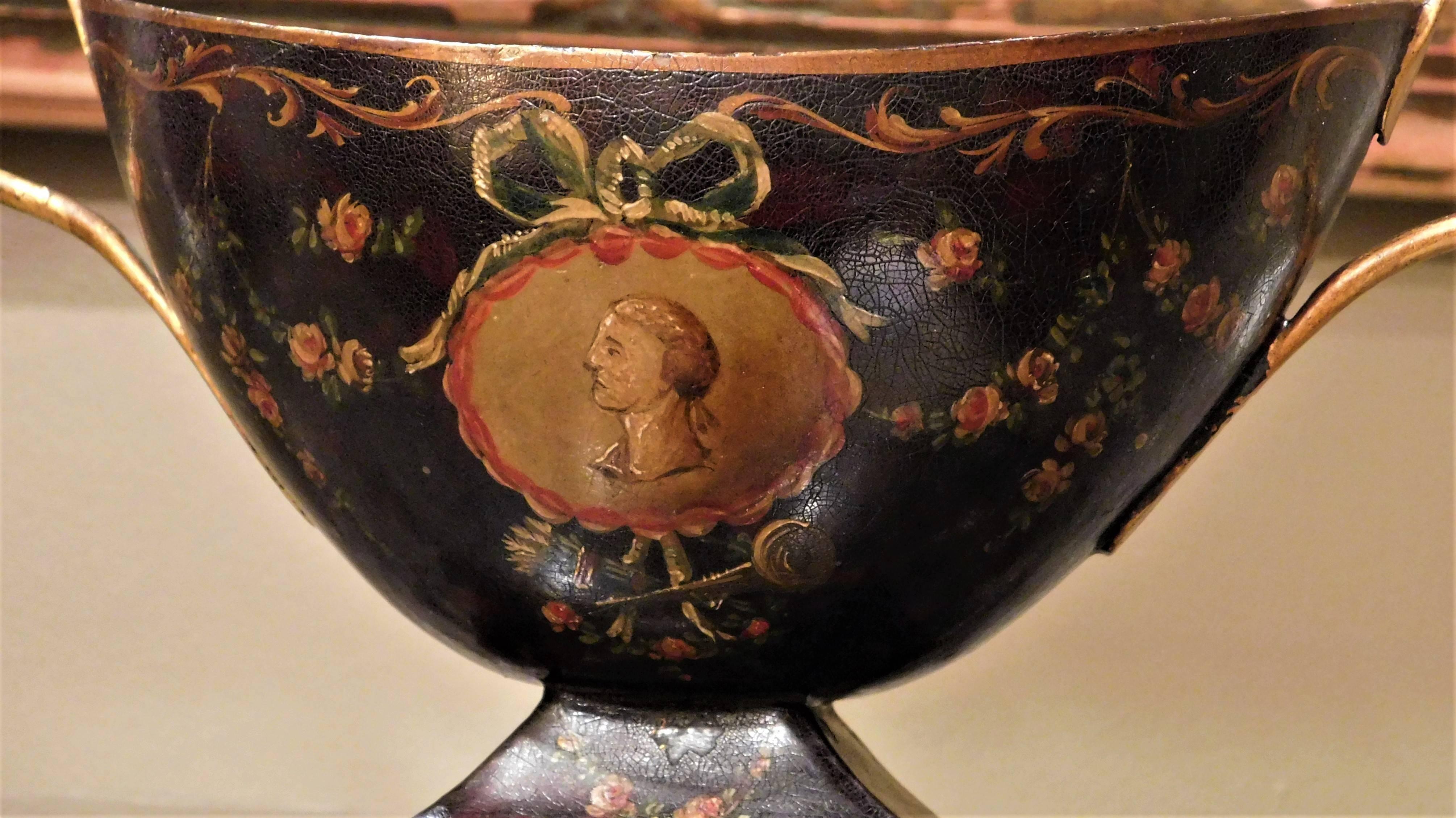 Each urn has a domed lid with finial above a navette-form body flanked by scrolled handles, on a rectangular plinth, decorated all-over with floral sprays, swags and scrolls centering cameo portrait medallions to the sides. Excellent patina.