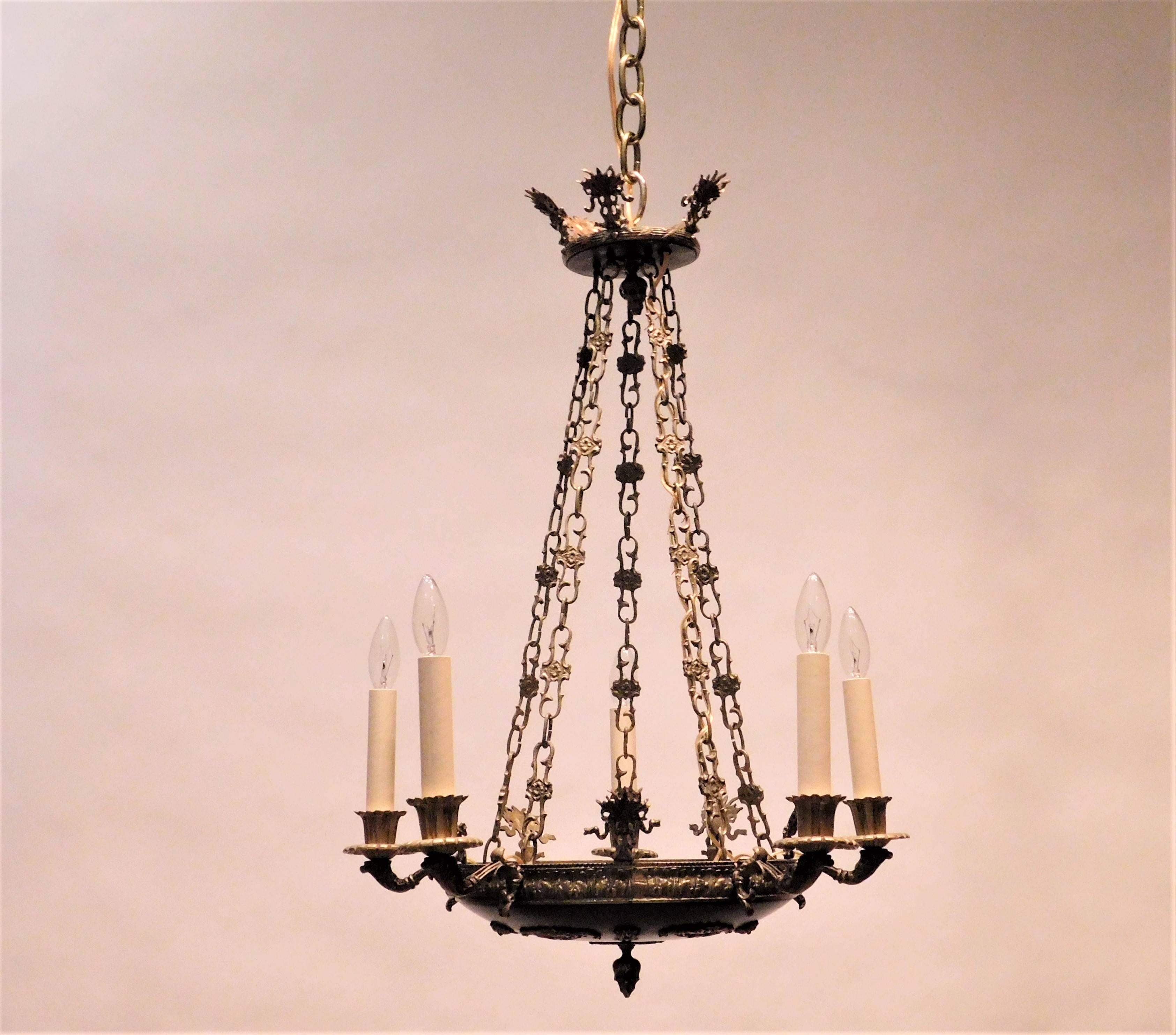 This fixture is brass, gilt brass and patinated brass. It is hand cast and finely wrought. Unique design details. Ceiling cap, hanging hardware, and 1 foot of chain included.
