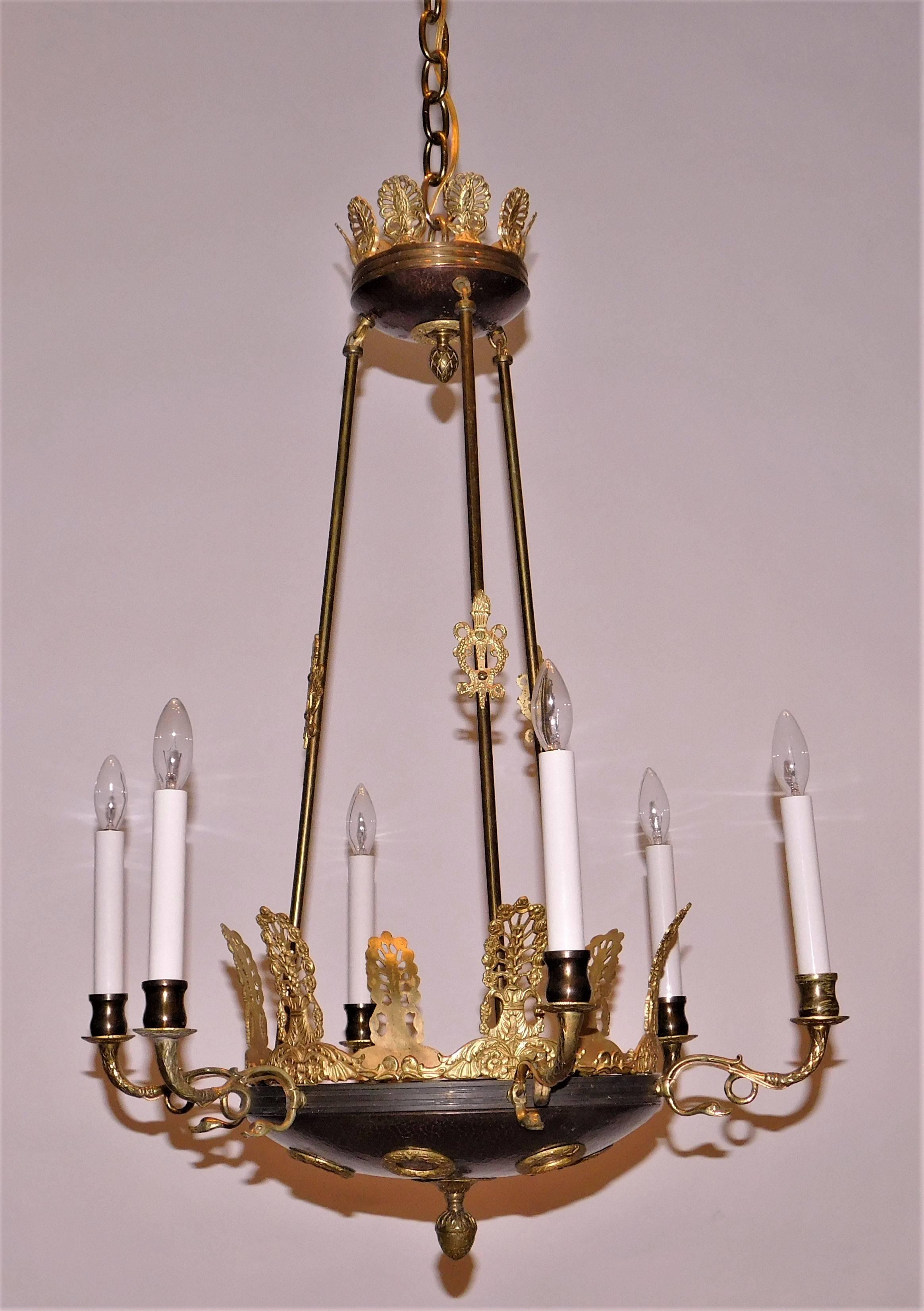 Hand made of bronze, beaten bronze and gilt bronze. The fixture has anthemions, wreaths and other Empire-related design elements. Ceiling cap, hanging hardware and 1 foot of chain included.
