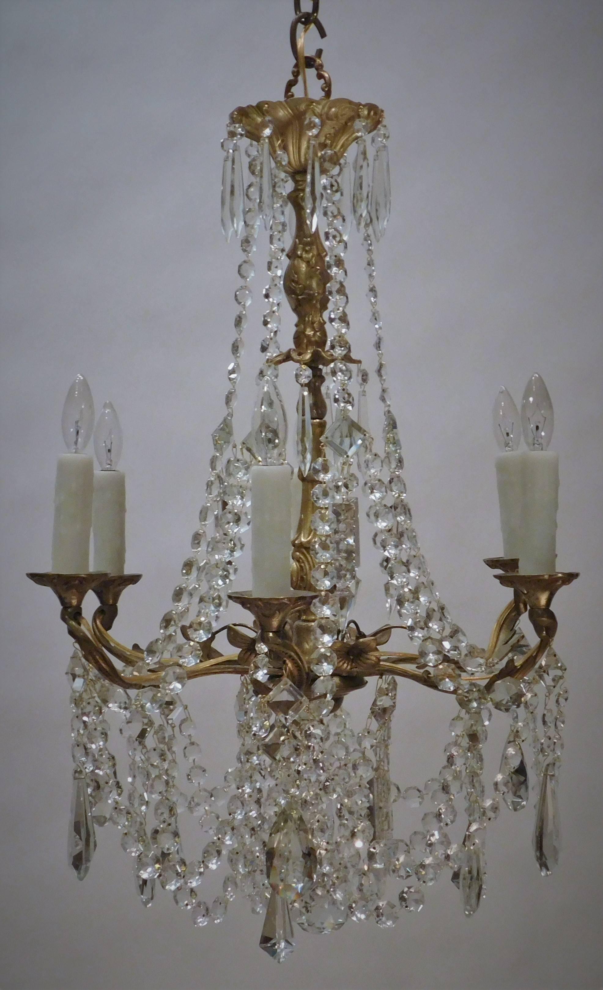 This rococo style chandelier is made of hand-cast gilt brass with hand-cut lead crystal Swedish prisms. It is externally (or French) wired. Ceiling cap, hanging hardware and one foot of chain included.