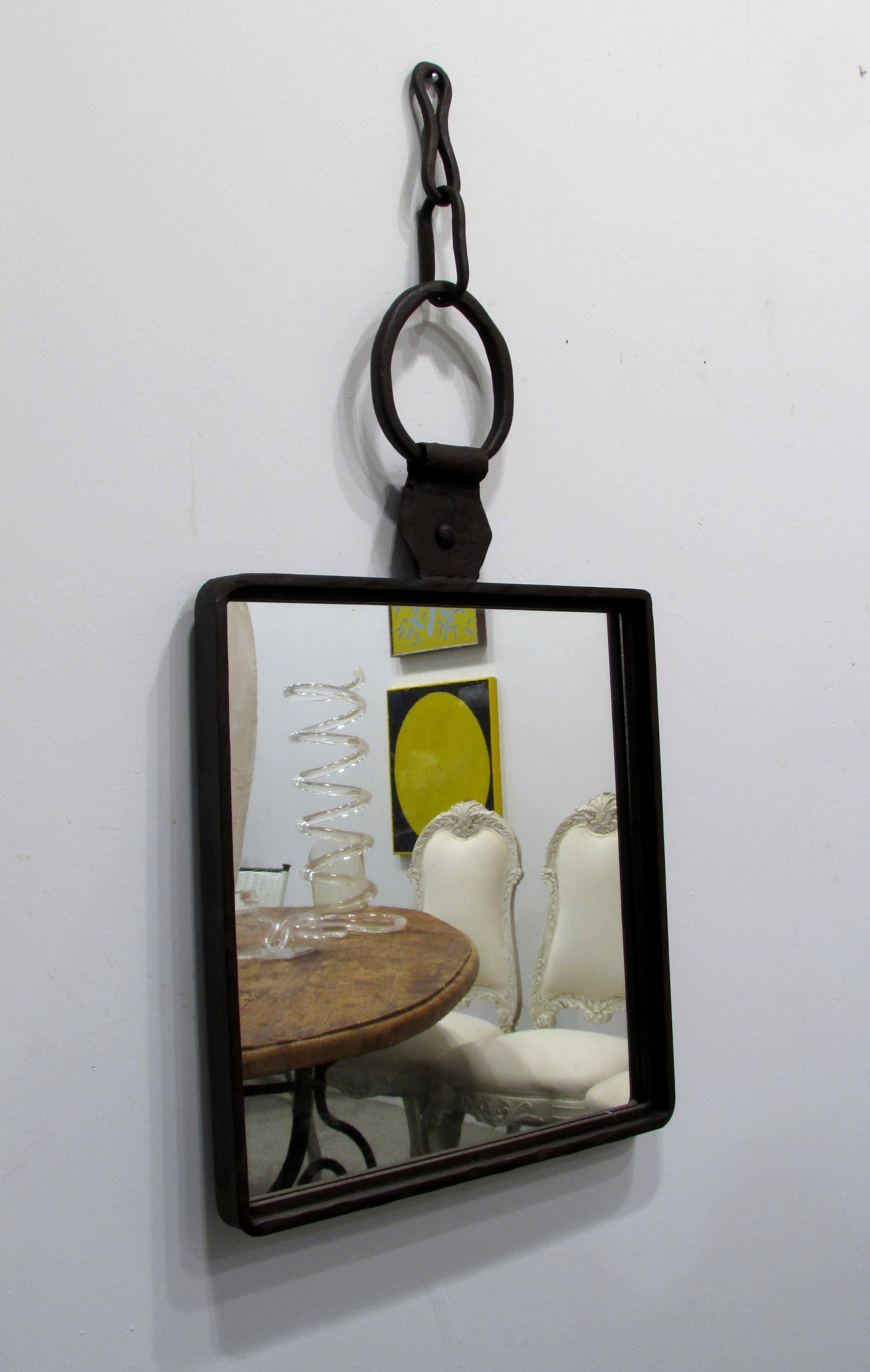 Brutally crafted wrought iron mirror with large hook and links at the top.